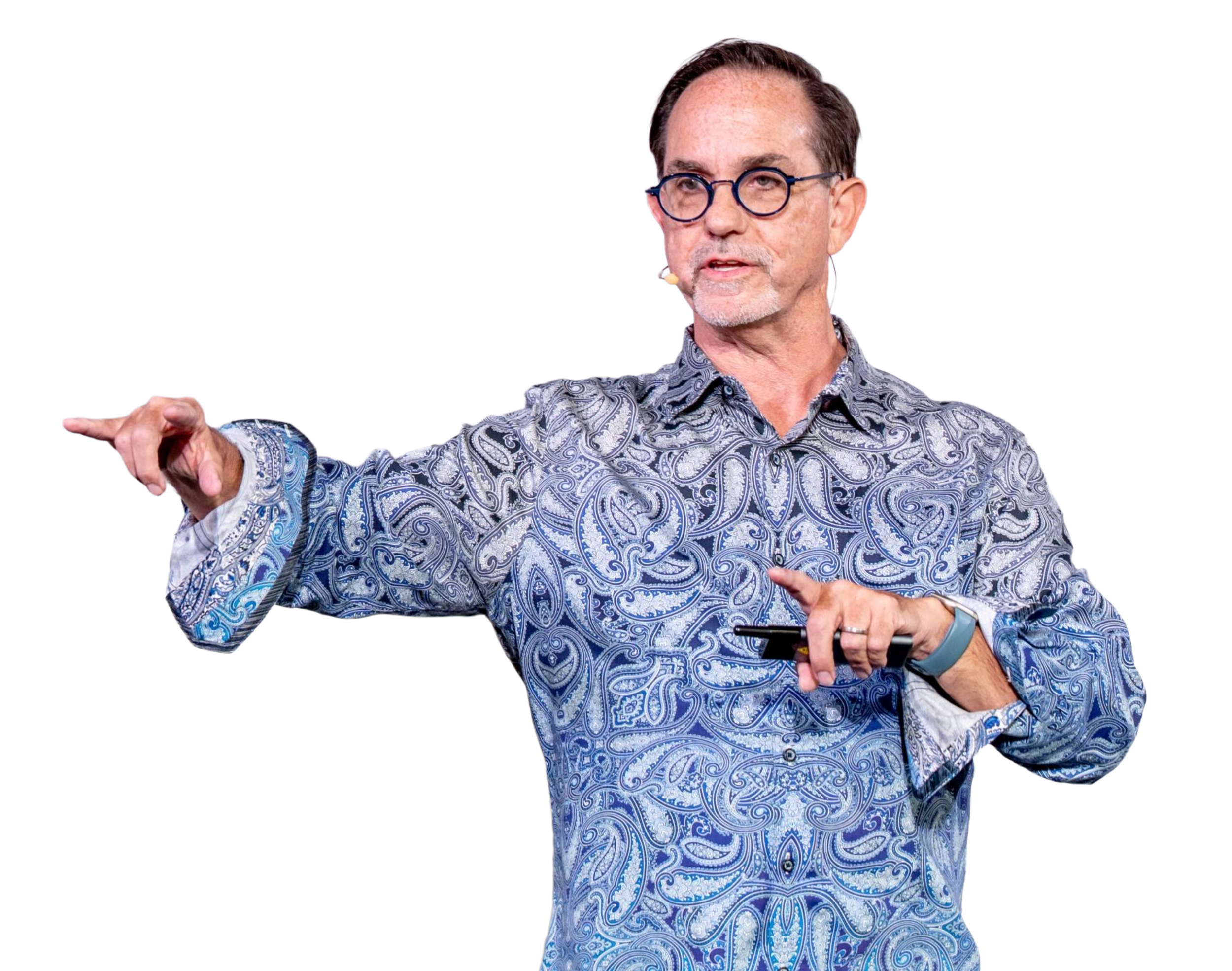 A man with glasses and a patterned shirt pointing to his left while holding a smartphone in his right hand.