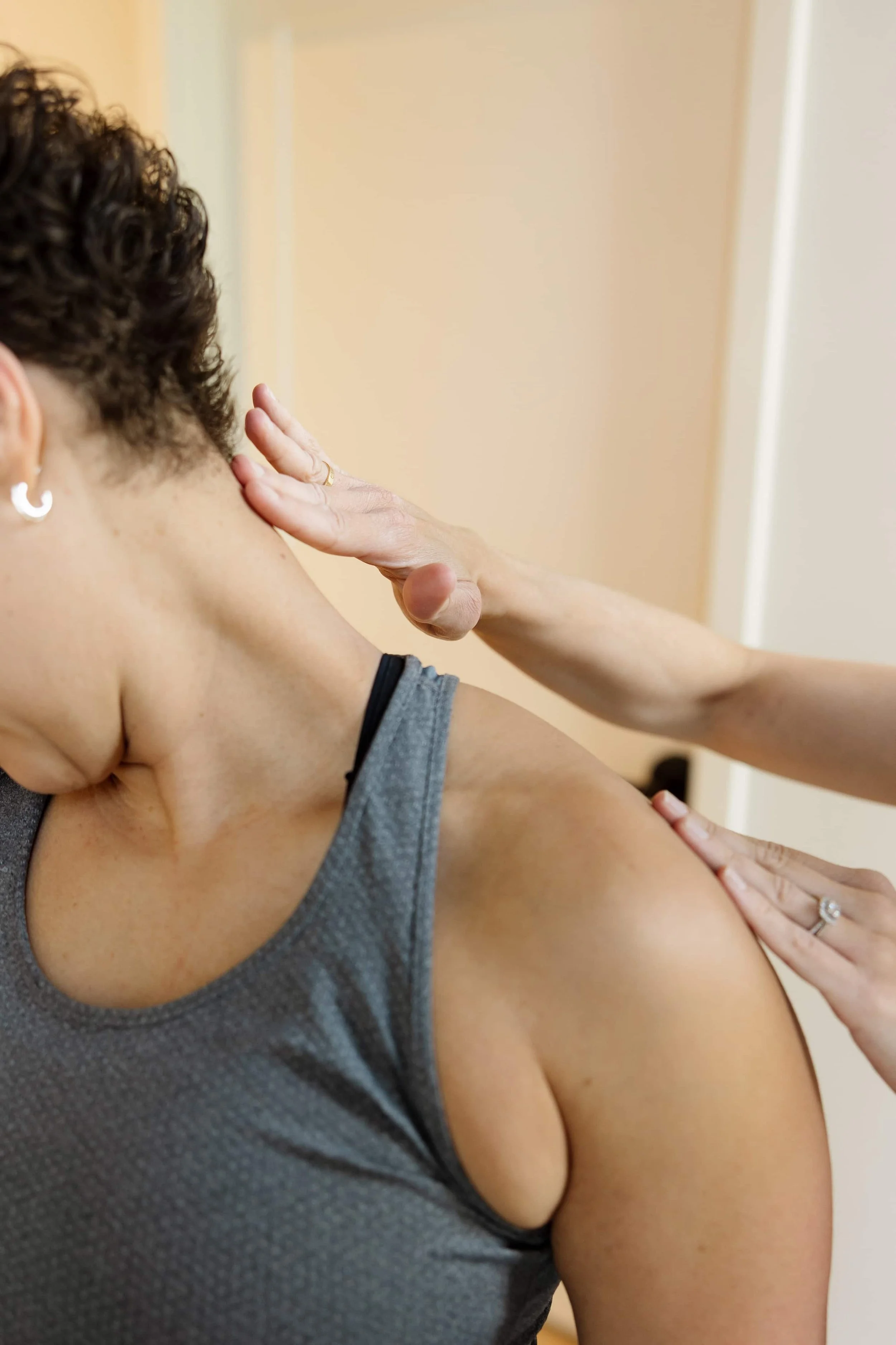 A woman receiving a massage on her shoulder from another person.