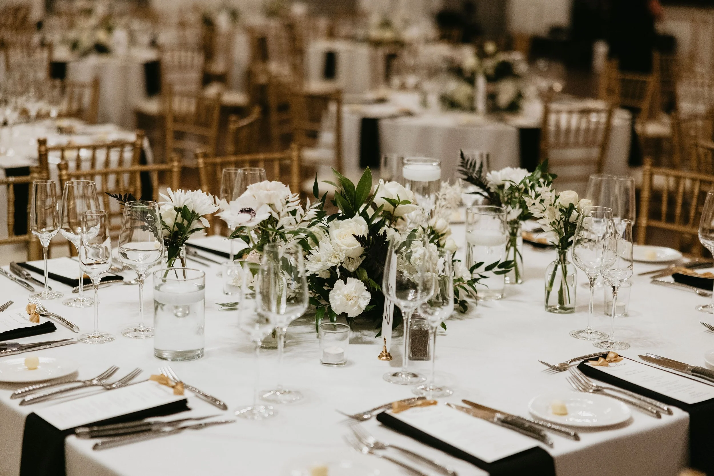 Elegant banquet table decorated with white flowers and glassware for a formal event.