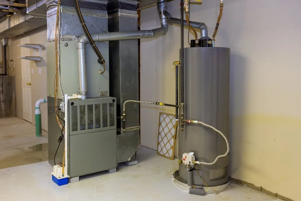 A basement furnace system with metal ducts, a gray water heater, and an air filter.