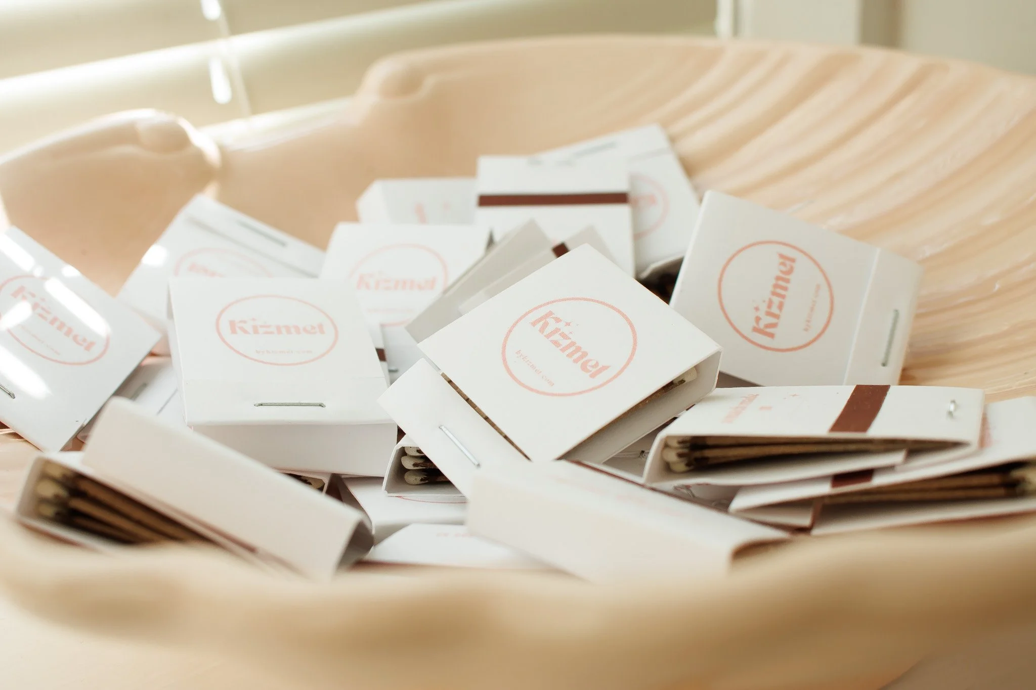 A wooden bowl filled with matches in small white boxes labeled 'Kızmet'.
