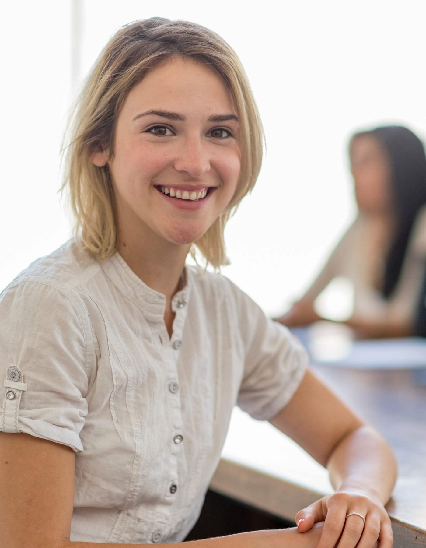 Woman smiling sitting at conference table after feeling relief from anxiety therapy.