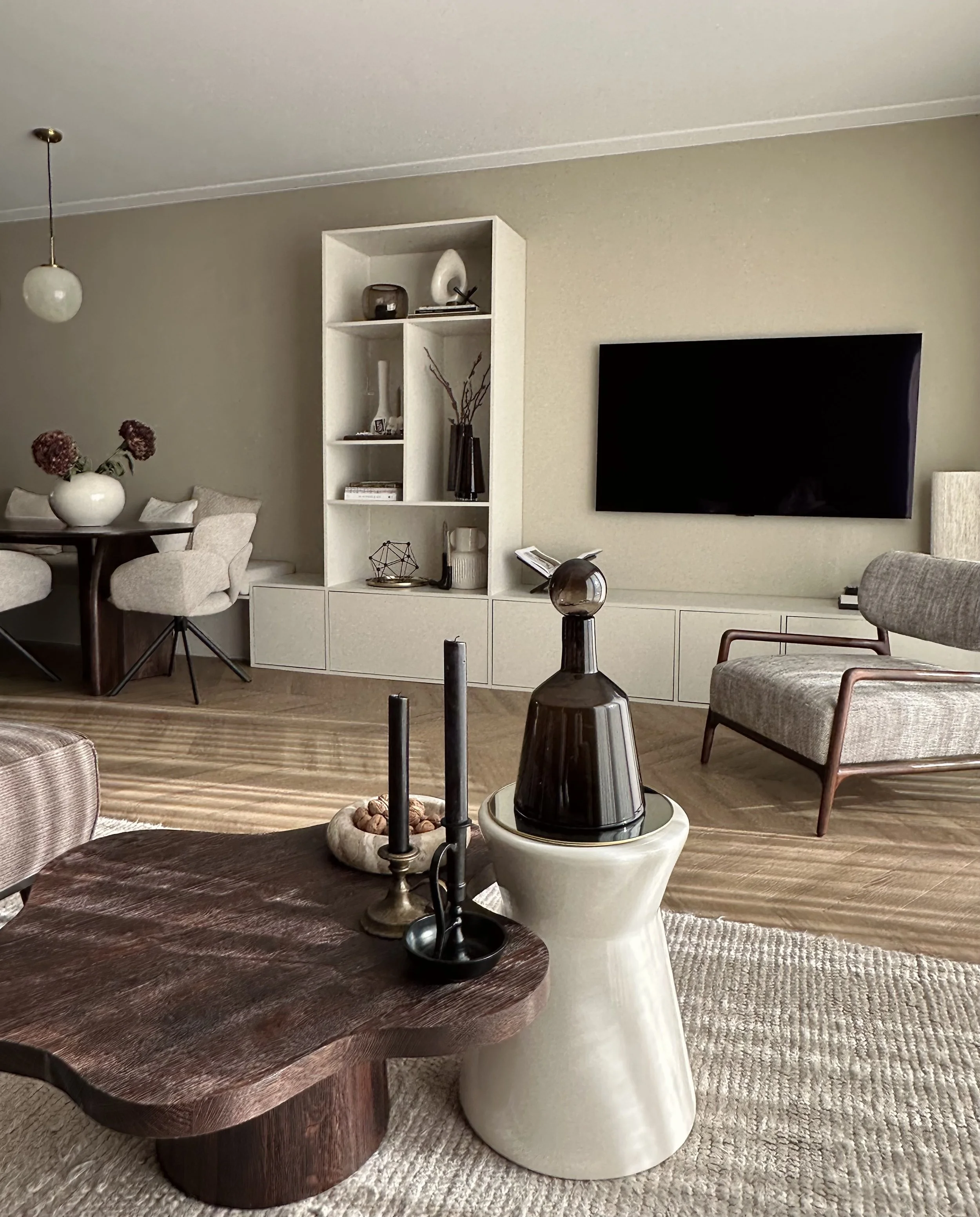 Een moderne woonkamer met houten salontafel en decoratieve objecten.