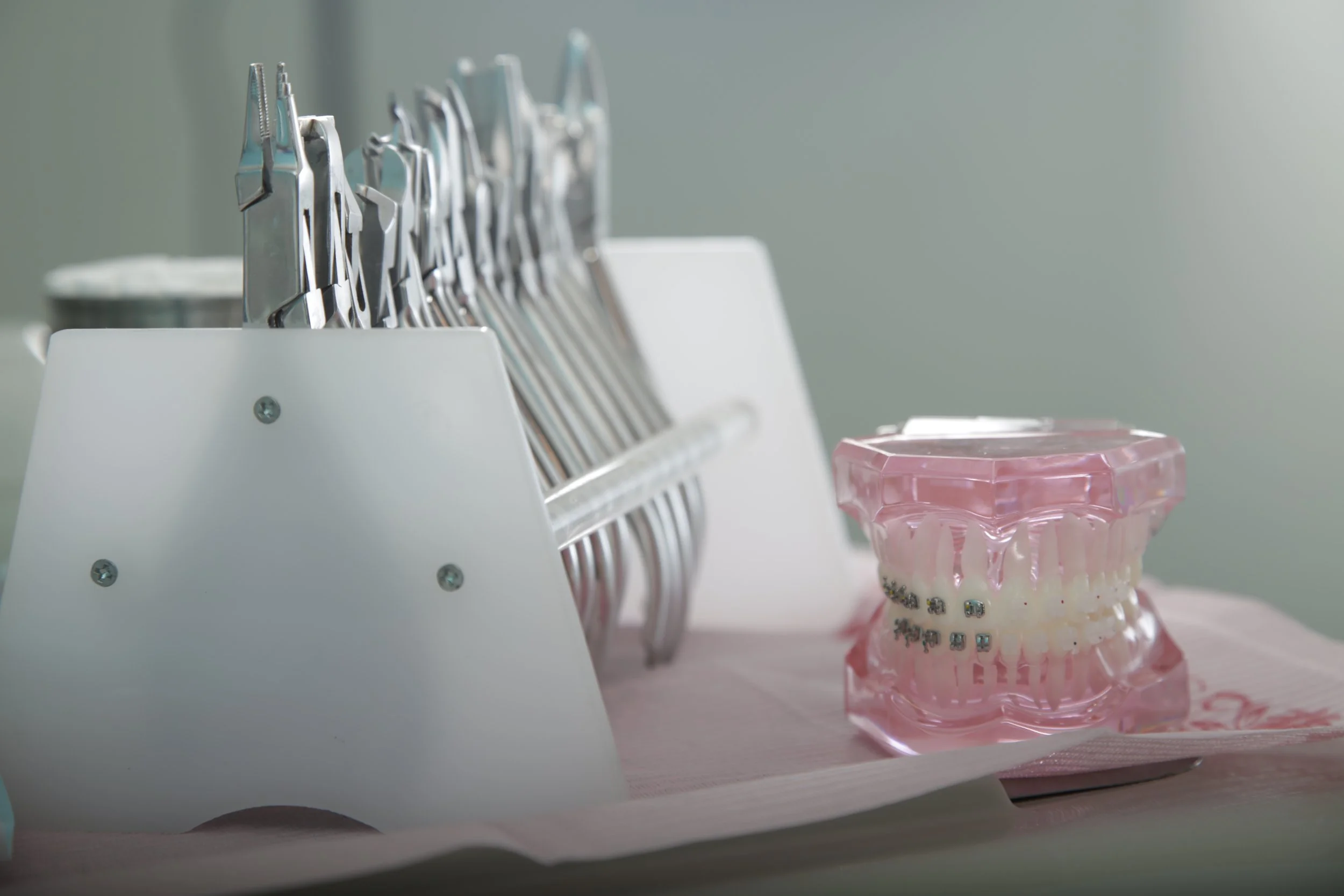 Modelo de dientes con brackets y herramientas odontológicas sobre una mesa
