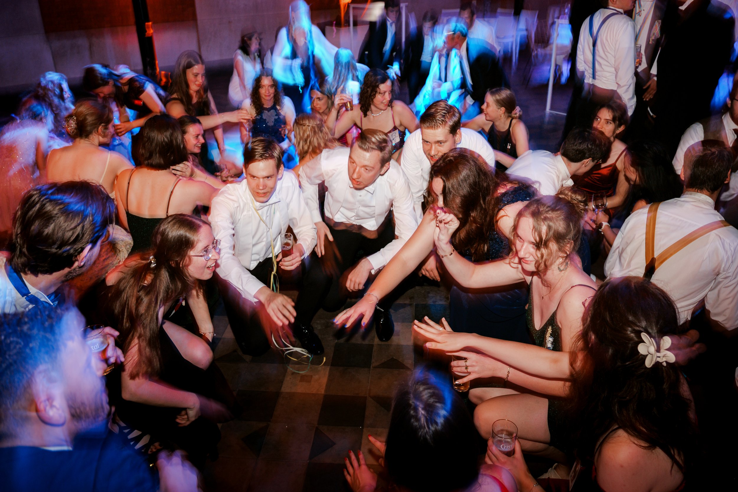 Mensen die dansen en plezier hebben op een feestje met kleurrijke belichting. Gefotografeerd door professionele gala fotograaf uit Nederland.