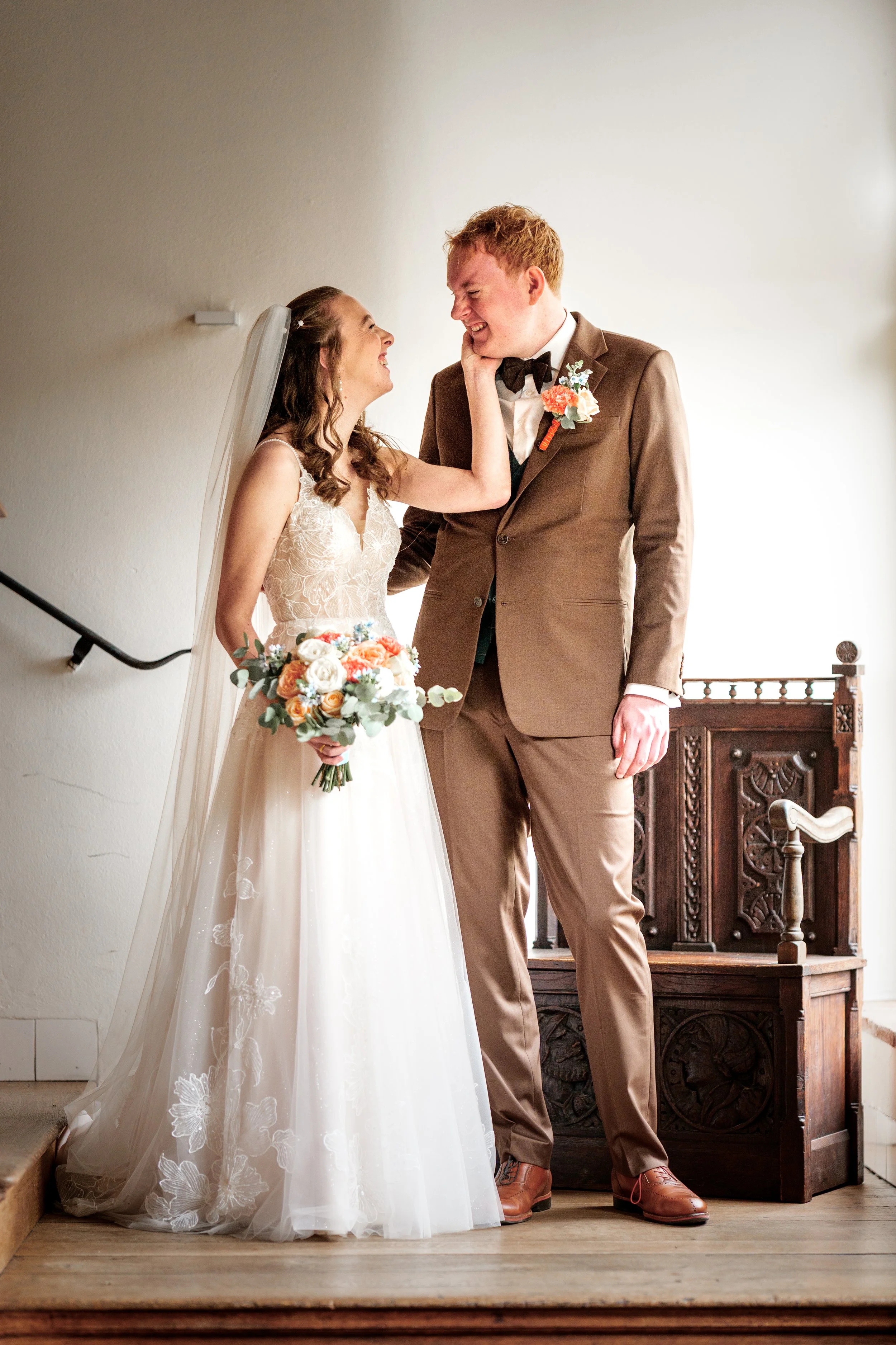Een bruidspaar in een klassiek trappenhuis, een voorbeeld van het 'Essentieel' fotografiepakket door een professionele trouwfotograaf uit Gelderland