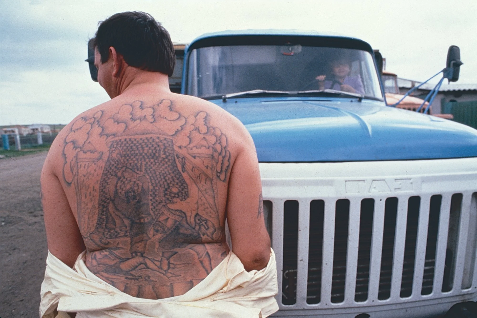 Igor, a Siberian truck driver who may or may not be familiar with the gulag, shows us his tattoos. 