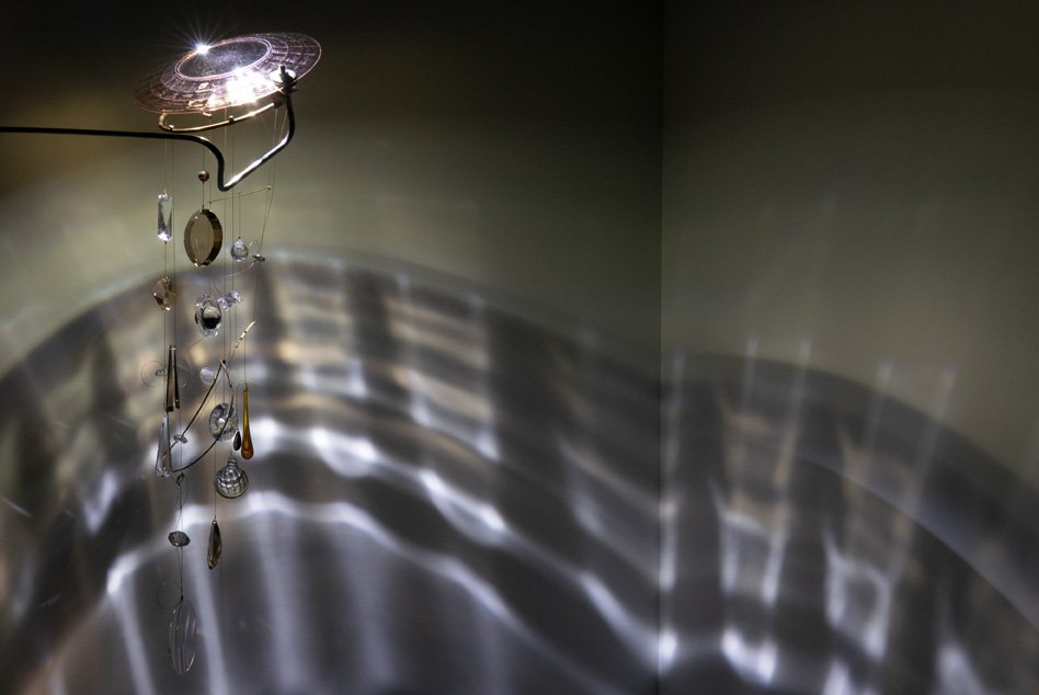 Illuminated detail shot of the plate and crystals, highlighting the quality of the glass that leads to a unique light cast.