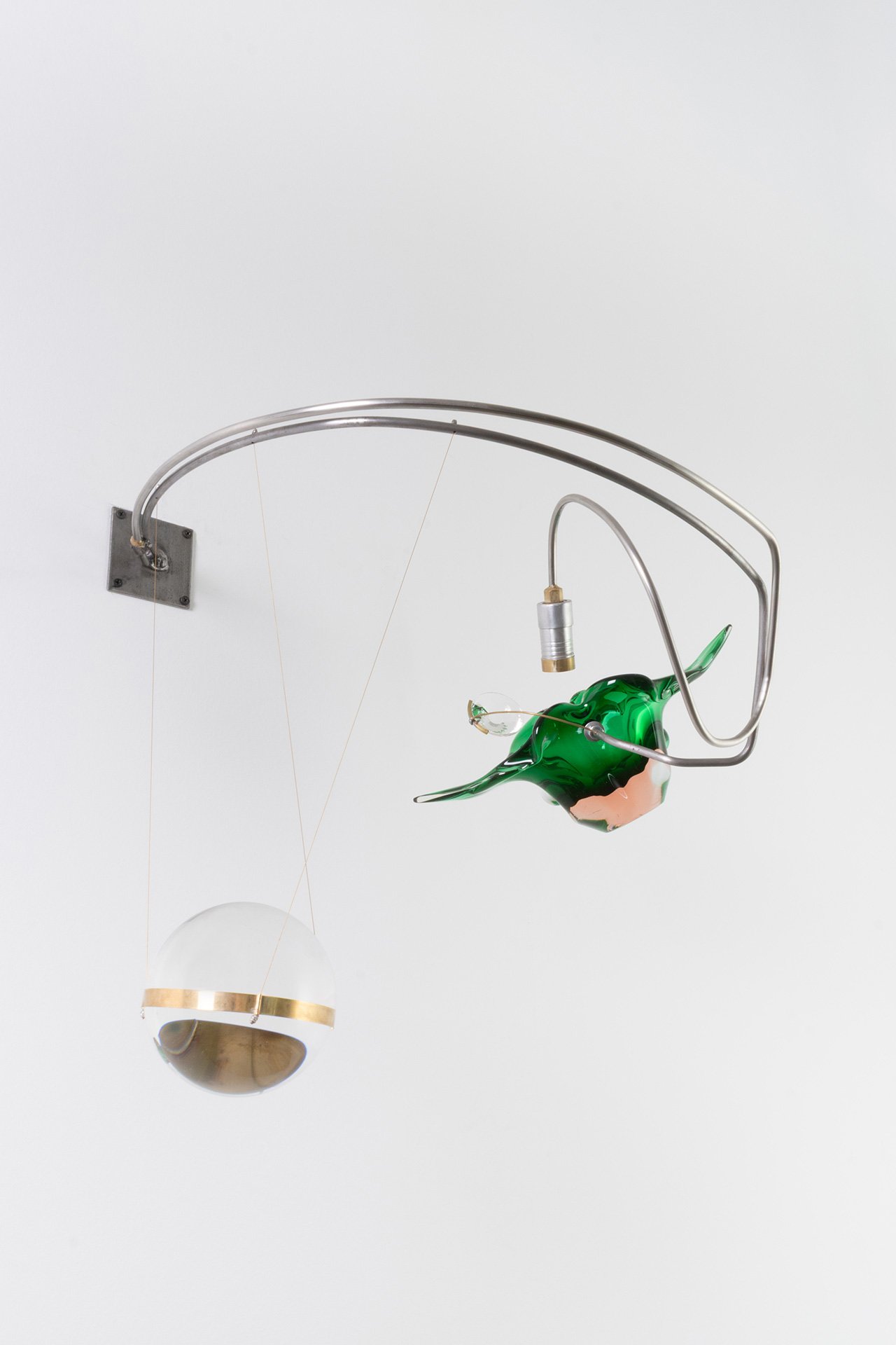 Unilluminated, the green flower-shaped Murano console bowl and clear glass sphere are emphasized.