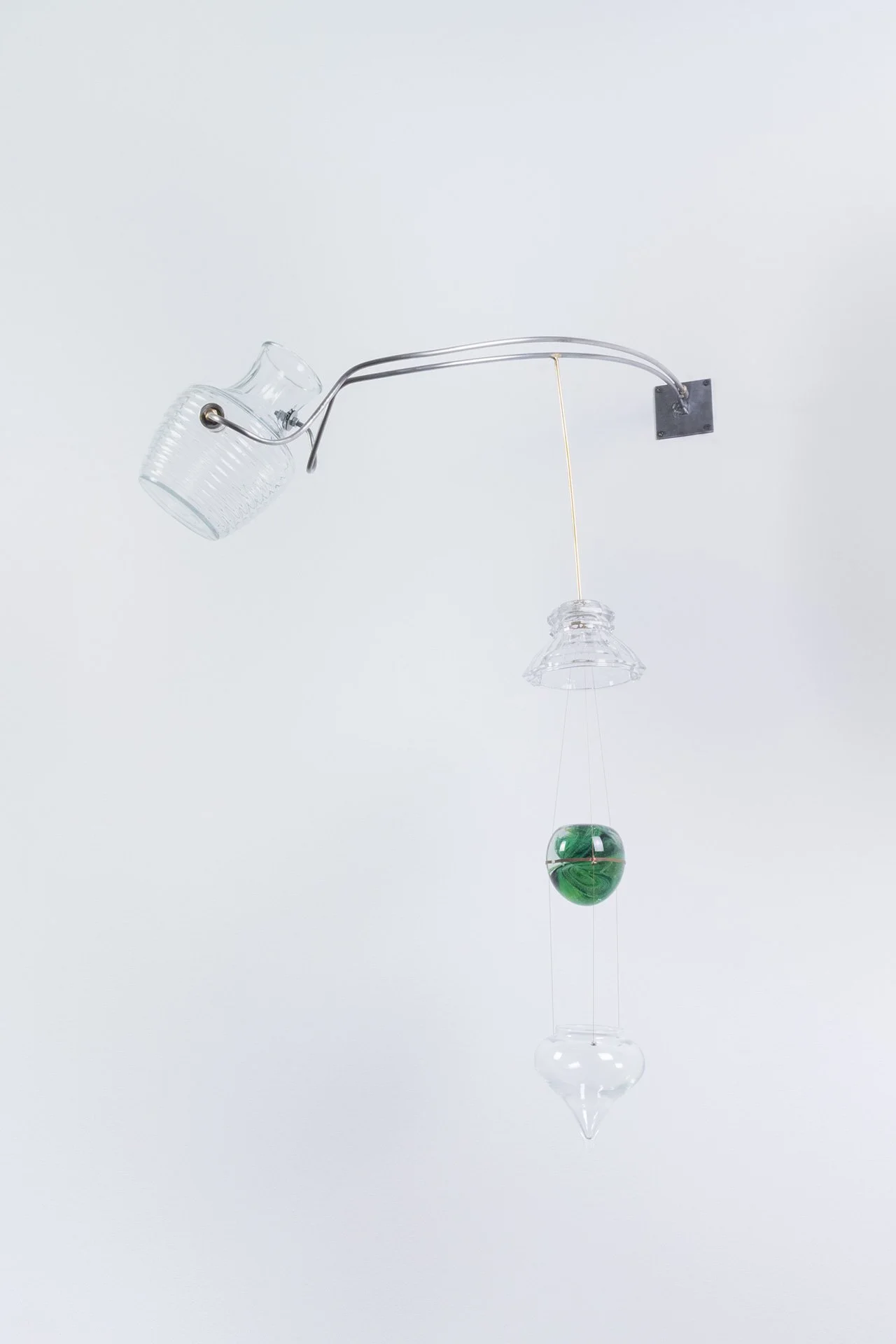 Unilluminated, the clear ribbed milk pitcher, clear faceted lampshade, clear onion drop ornament, and green Kerry paperweight are emphasized.