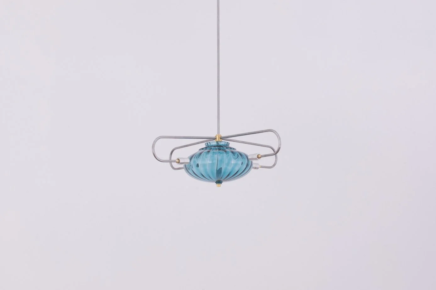 A modern chandelier with a blue glass shade and metal arms hanging from a ceiling.