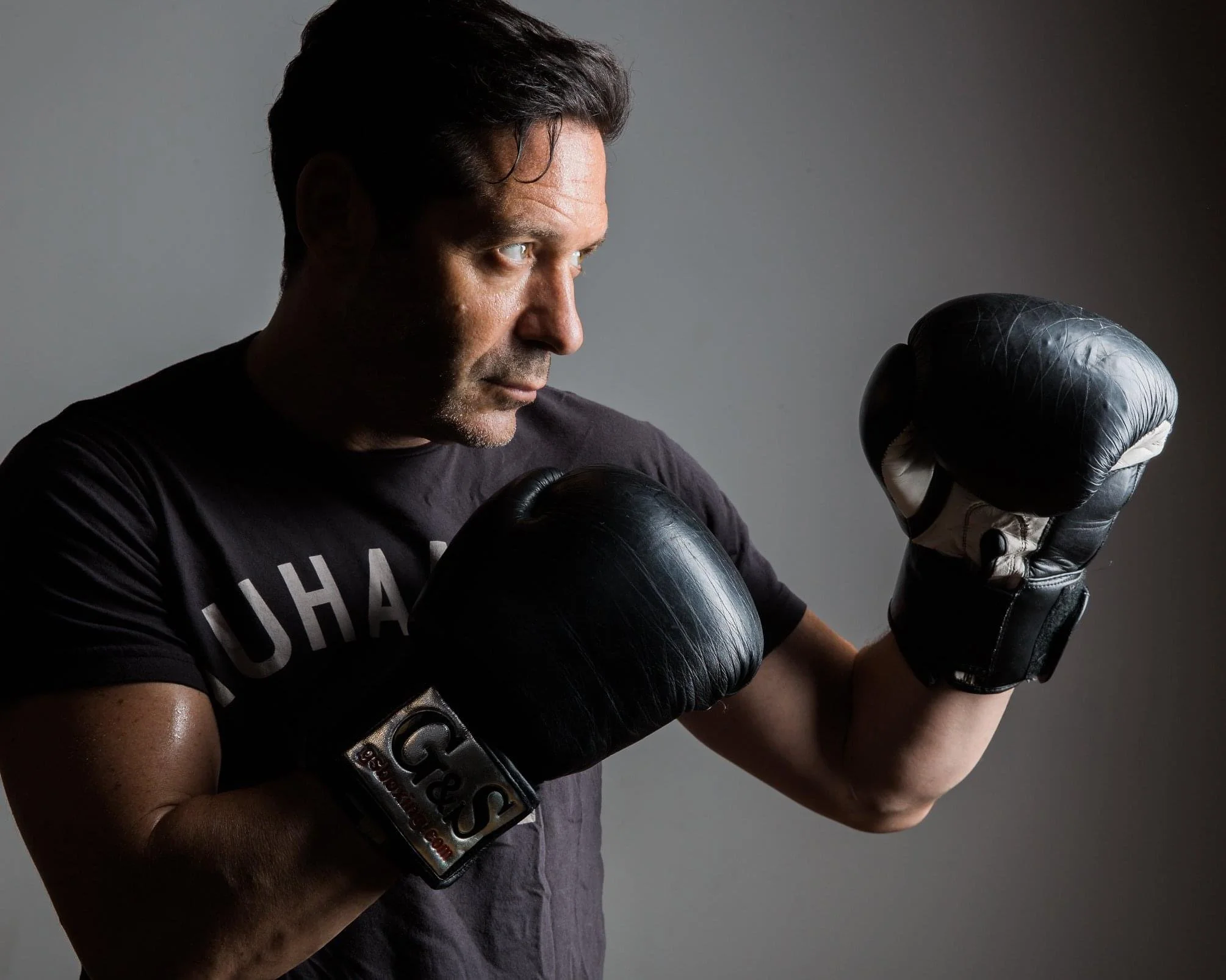 Boxer in black gloves practicing technique at Gleason's facility