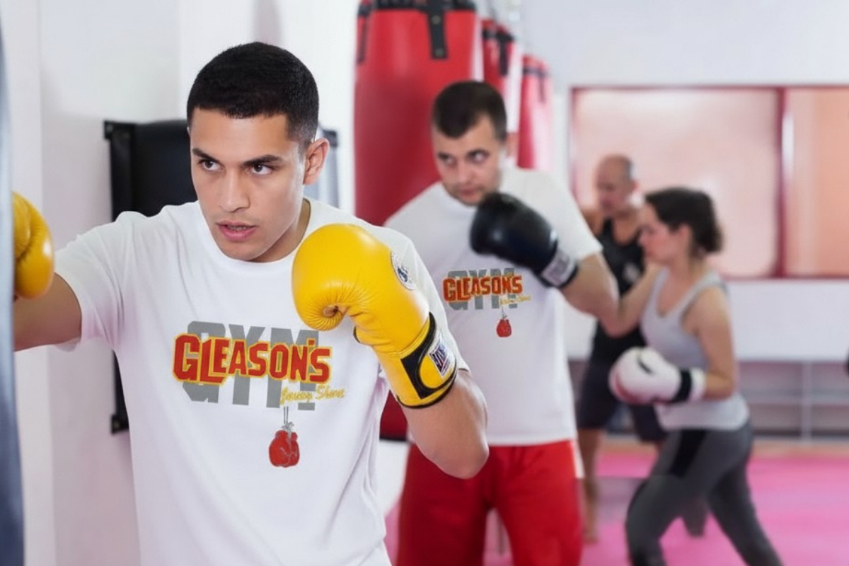 Boxer in Gleason's shirt with yellow gloves training in advanced combat club class