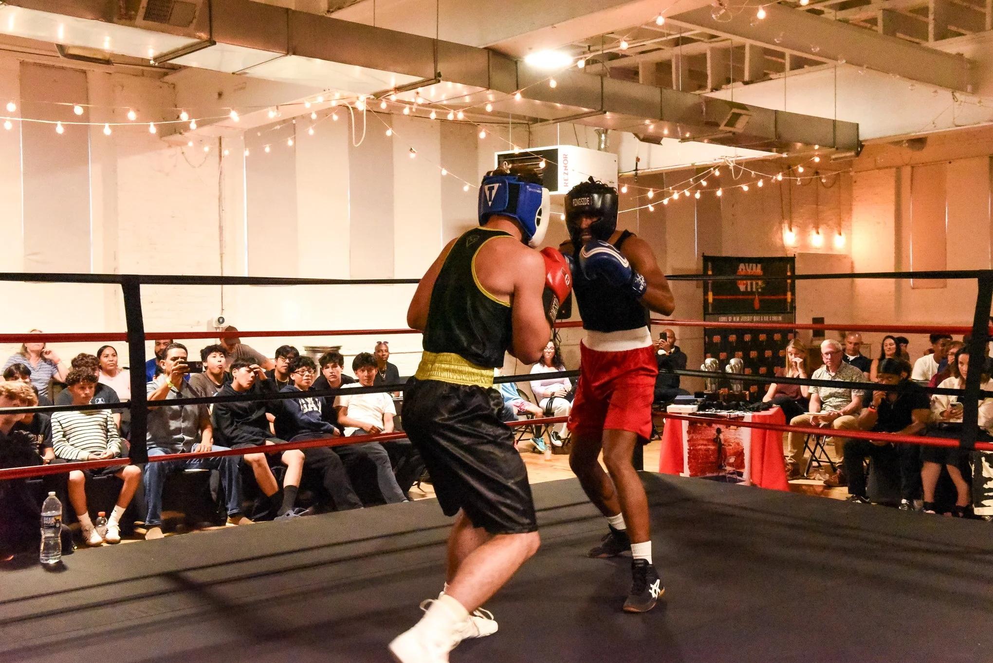 Amateur boxing match with two competitors in ring and crowd watching at Gleason's New Jersey