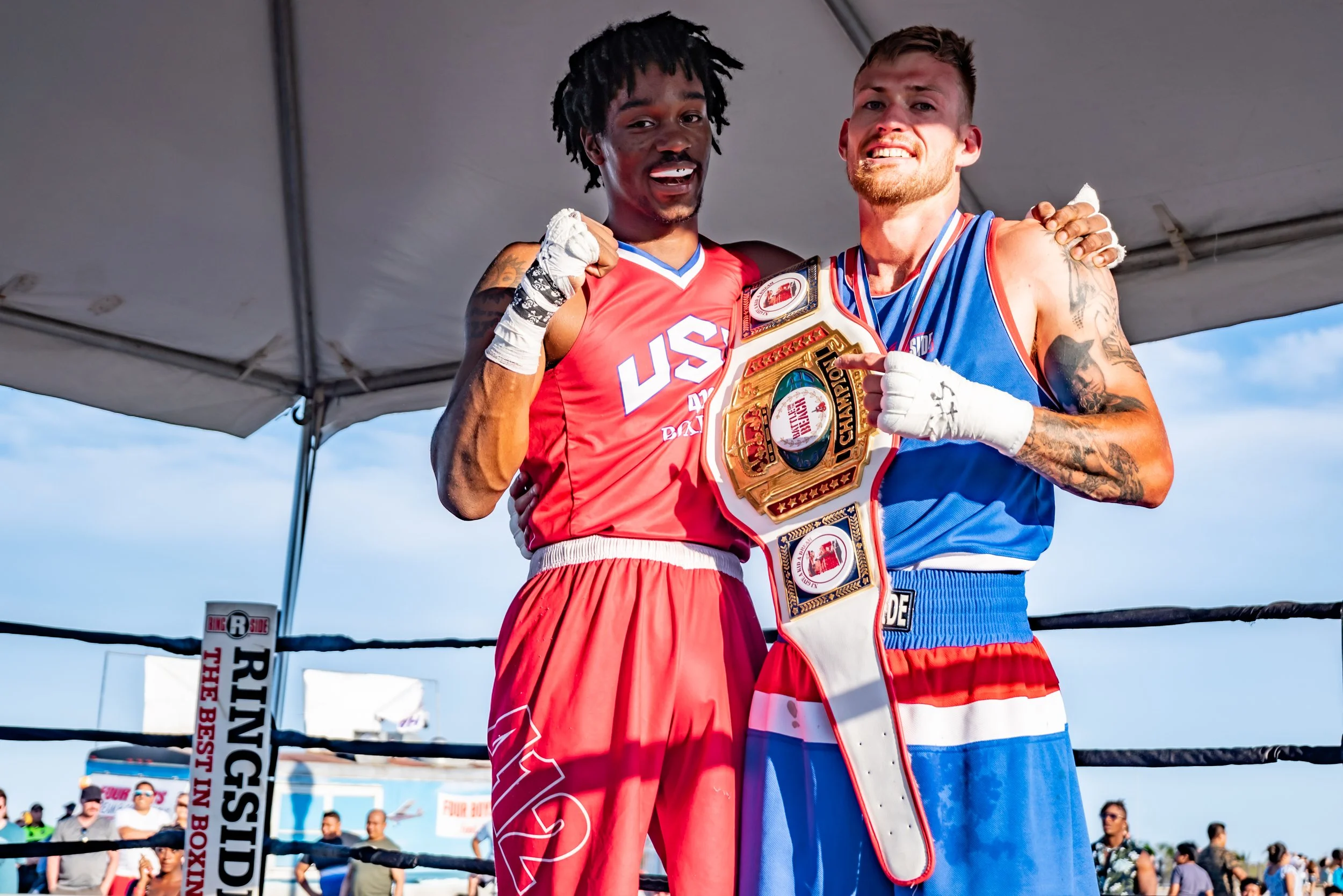 Two amateur boxers with championship belts celebrating victory in boxing ring at Gleason's New Jersey