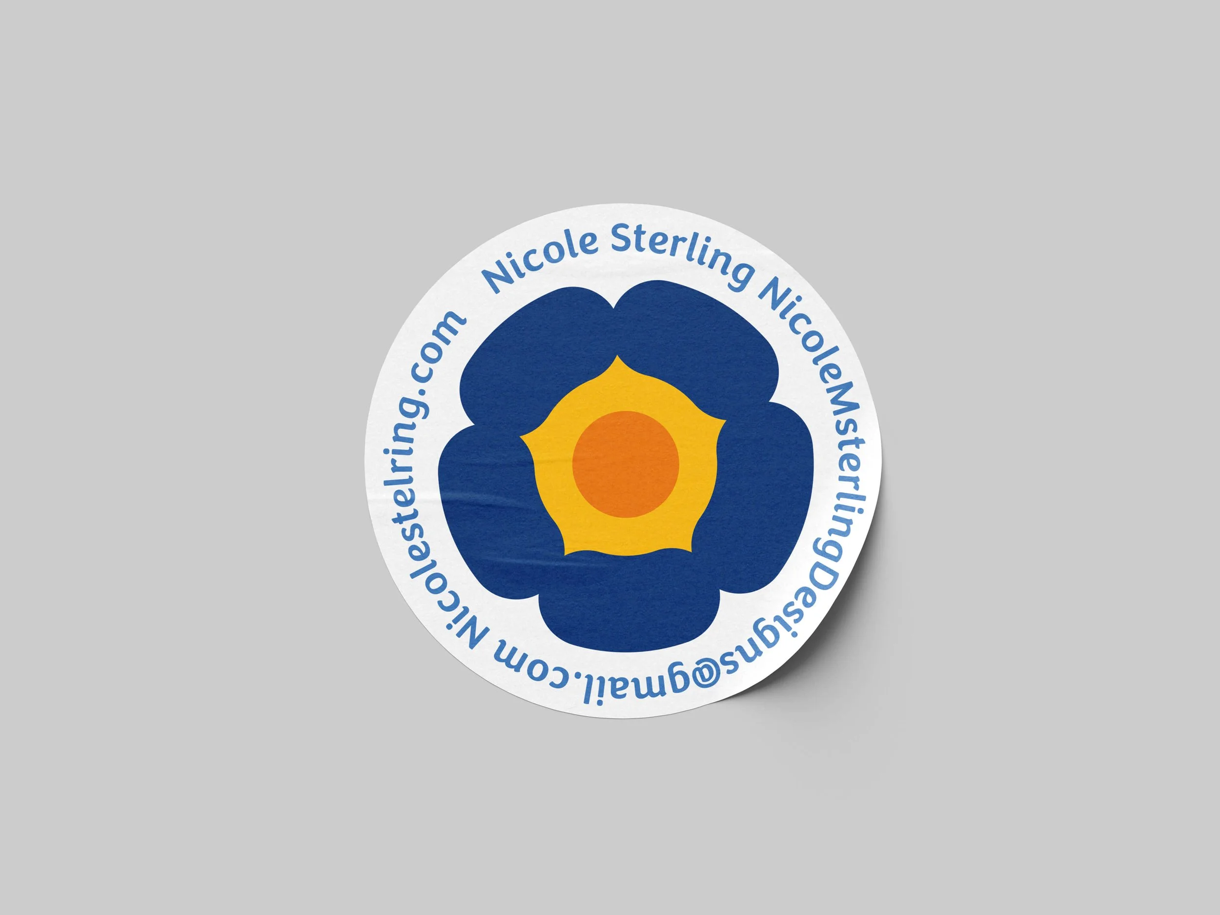 A round sticker with a blue flower design, yellow center, and orange dot in the middle, with blue text around the edge that reads 'NicoleSterling.com Nicole Sterling NicoleSterling@gmail.com'.