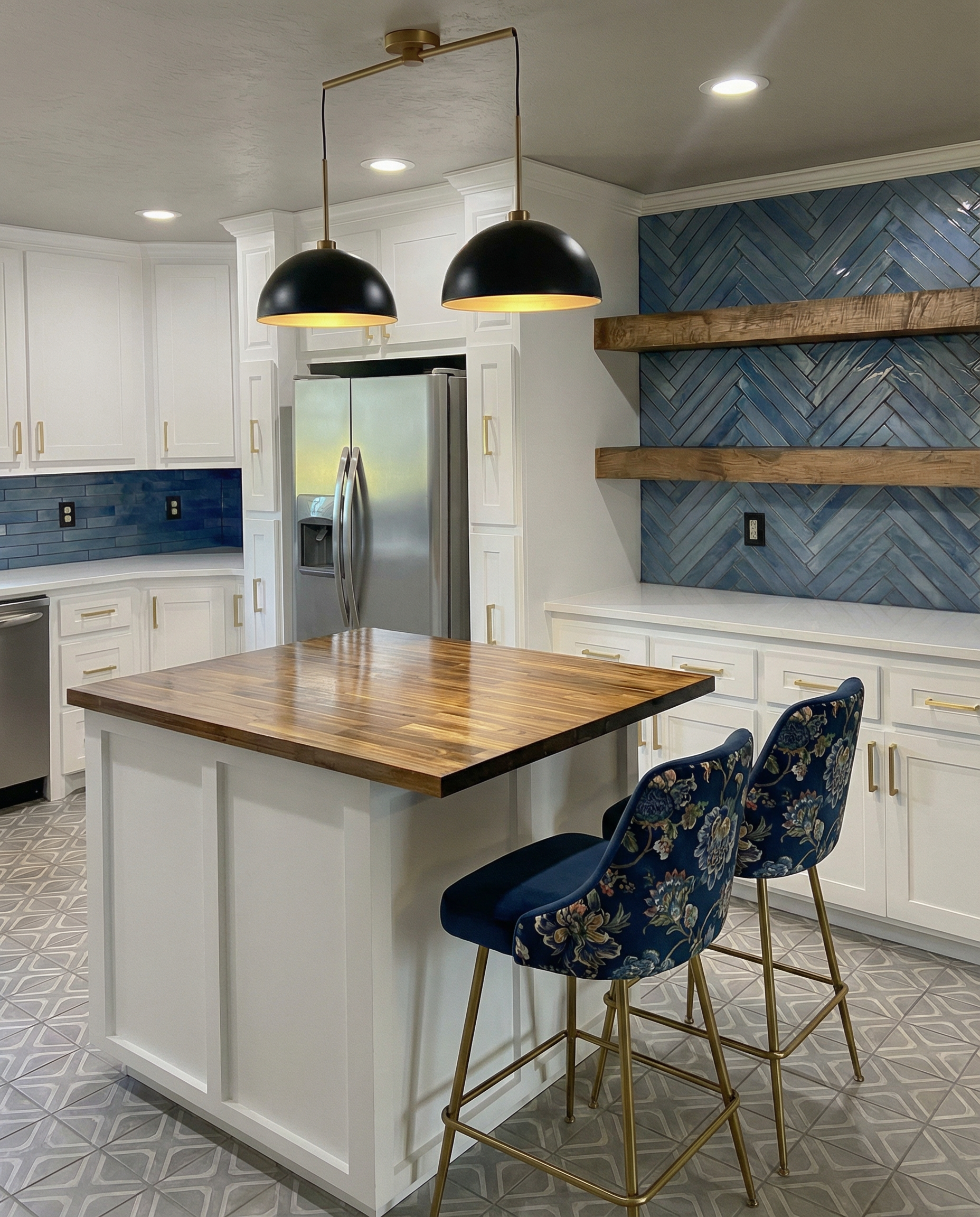 Kitchen with white cabinets, stainless steel refrigerator, blue herringbone backsplash, wooden shelves, island with wooden countertop, and two blue floral patterned bar stools.