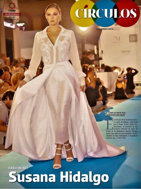 Mujer modelando vestido de novia en pasarela, con fondo de público y fotógrafos. Encabezado del artículo de revista con título y nombre de Susana Hidalgo.