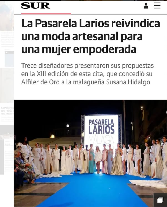 Desfile de moda con modelos con vestidos blancos y colores pastel en una pasarela azul en la calle durante la noche, con un cartel que dice 'Pasarela Larios Málaga'.