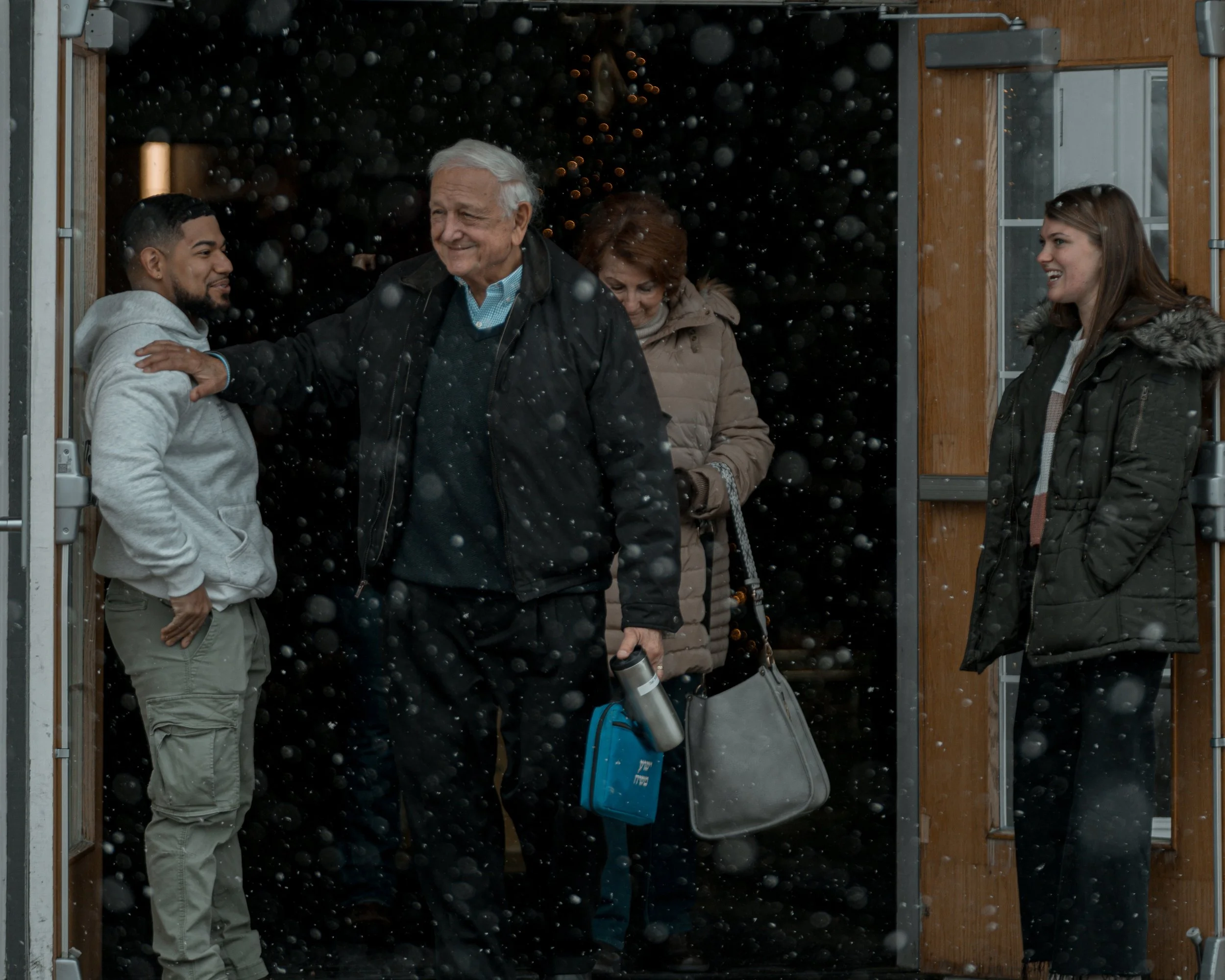 Family welcoming loved one home at the door in snowy weather