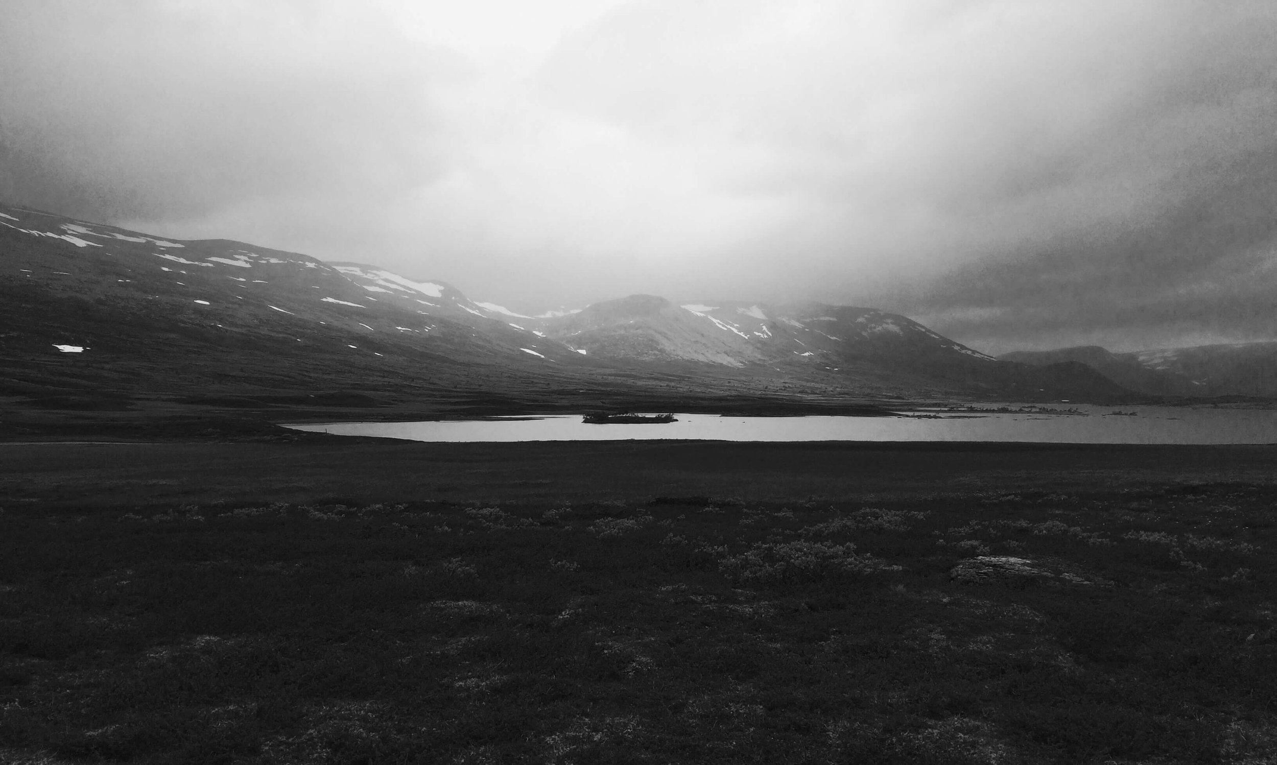 Black and white panorama image of a lake and a mountain background