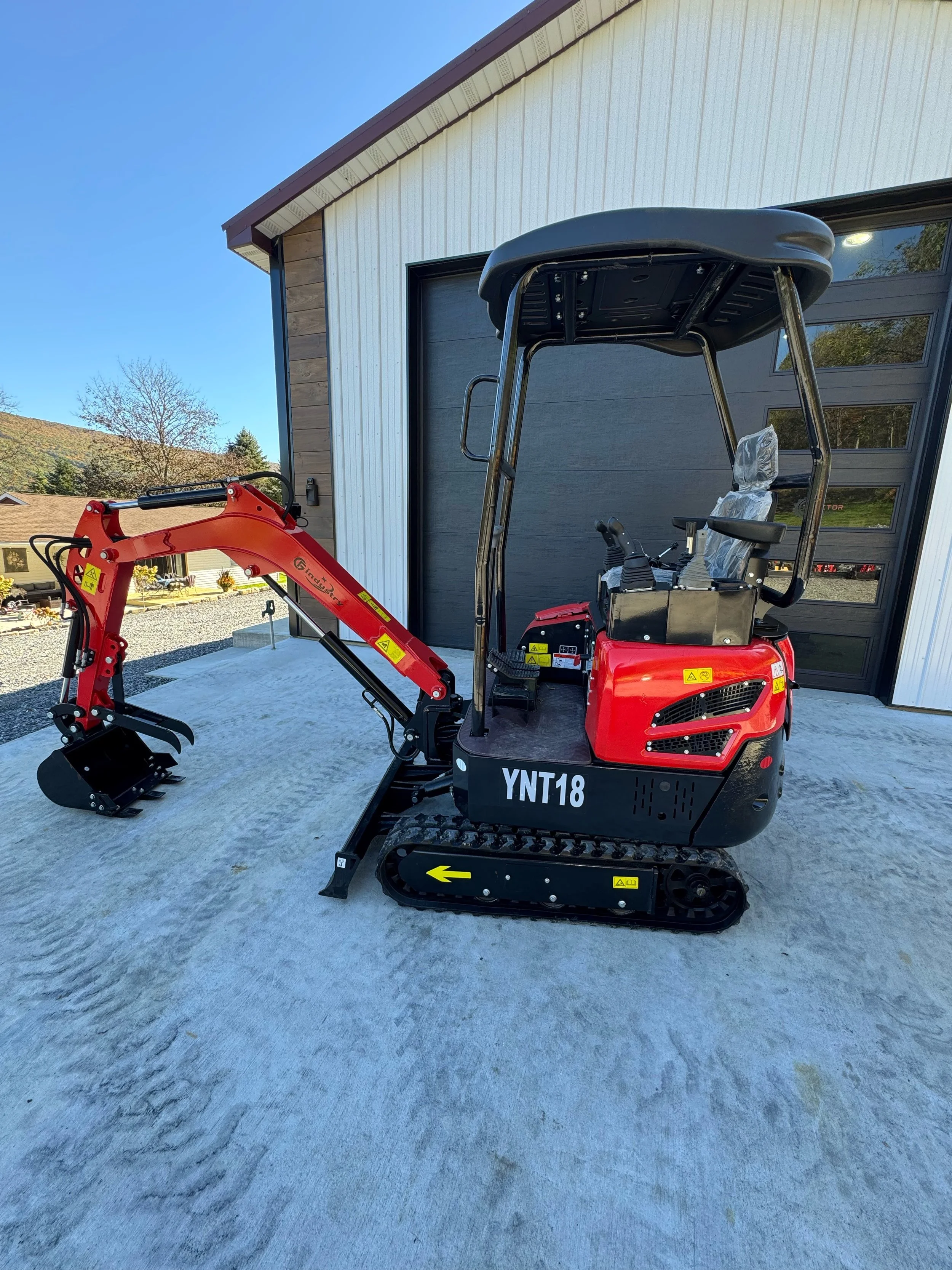 Wide left-side view of a new YNT18 mini excavator with rubber tracks and canopy