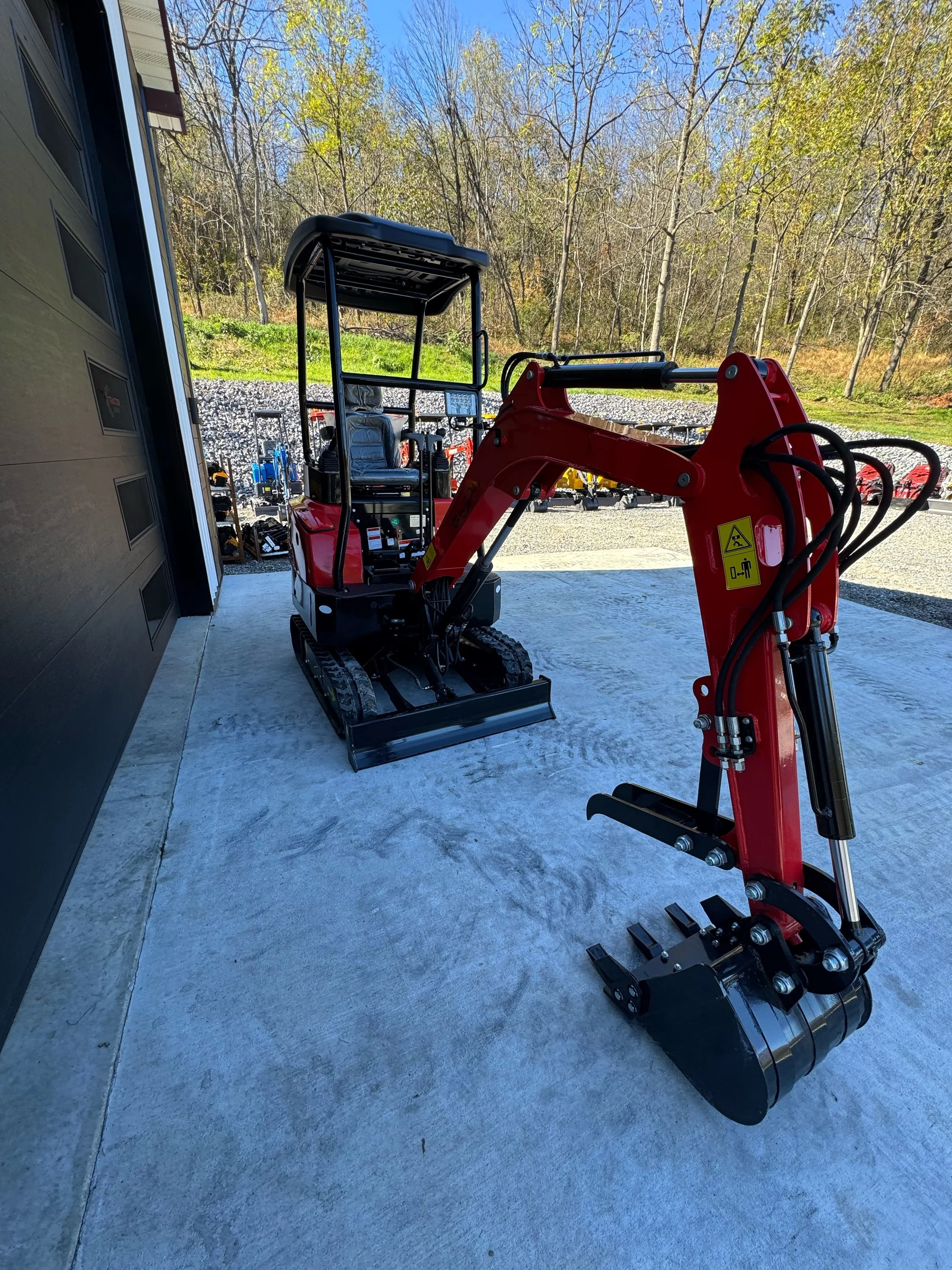 Front three-quarter view of a red YNT18 mini excavator with bucket and thumb