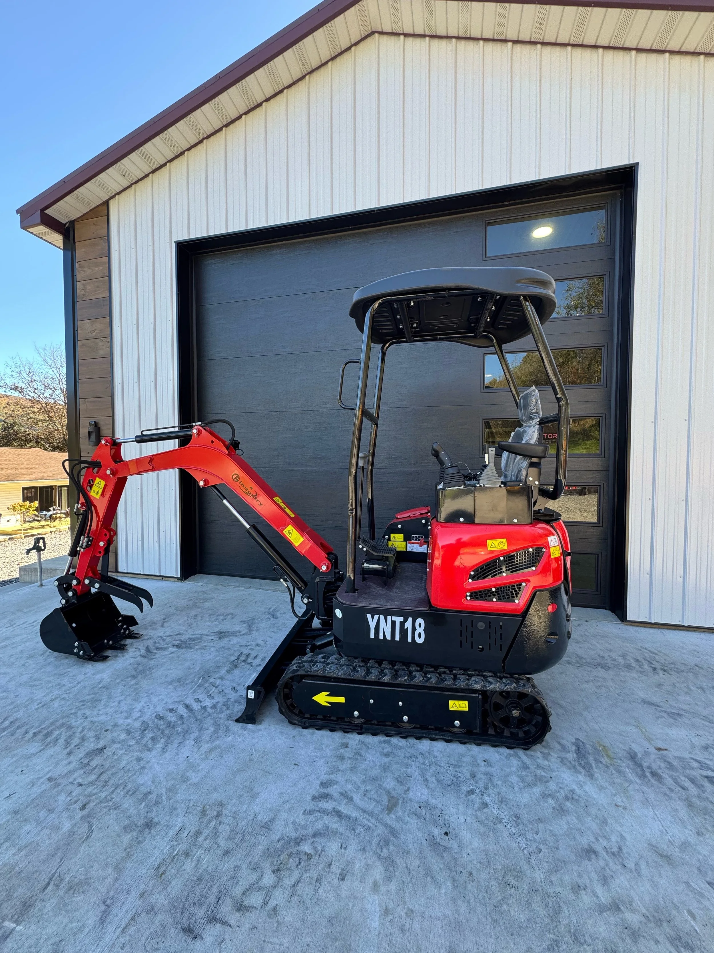 Red YNT18 mini excavator with canopy, left side, parked at the TractorSource garage in Altoona PA