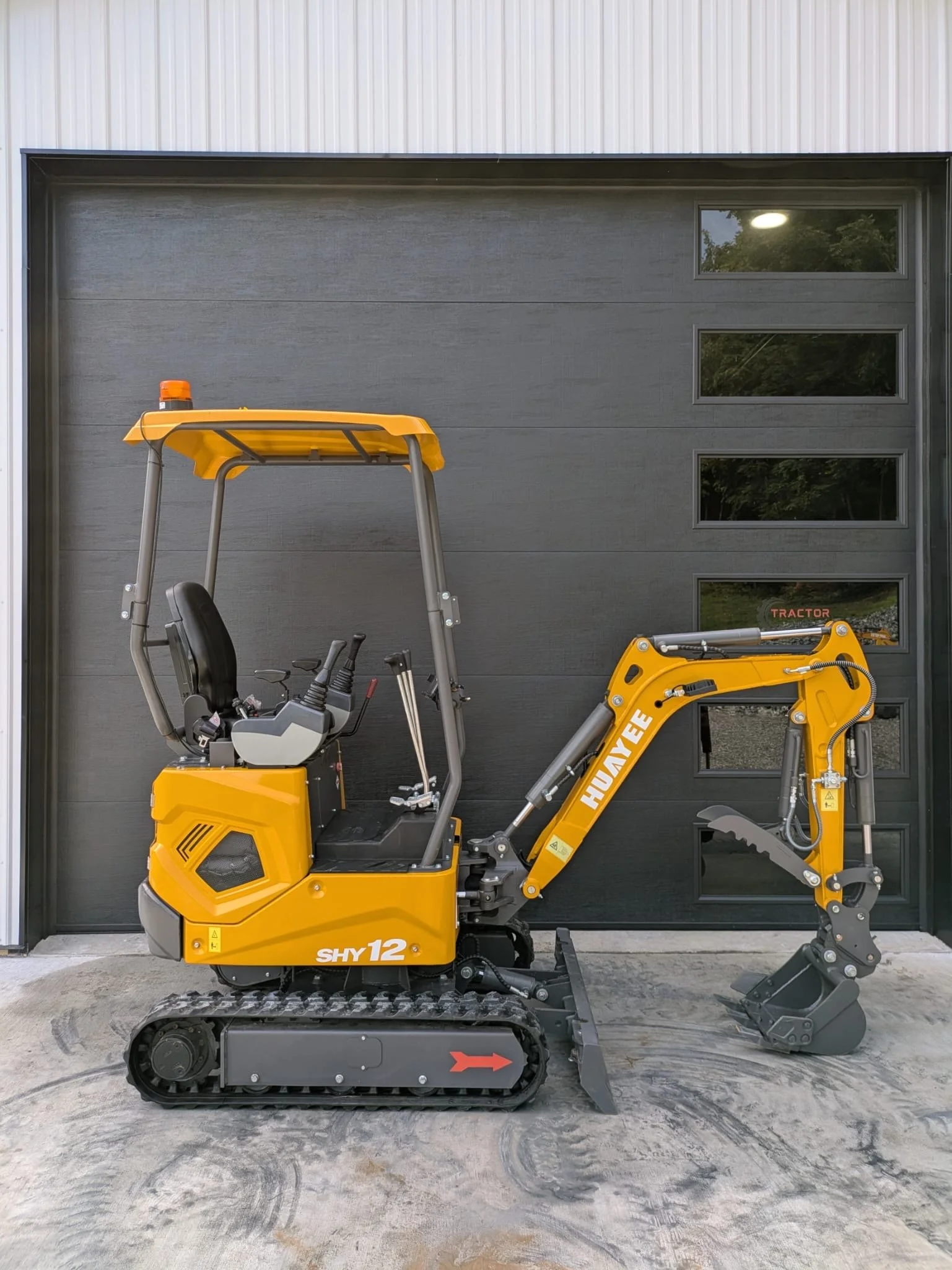 Huayee SHY12 mini excavator side view in front of TractorSource garage, Altoona PA