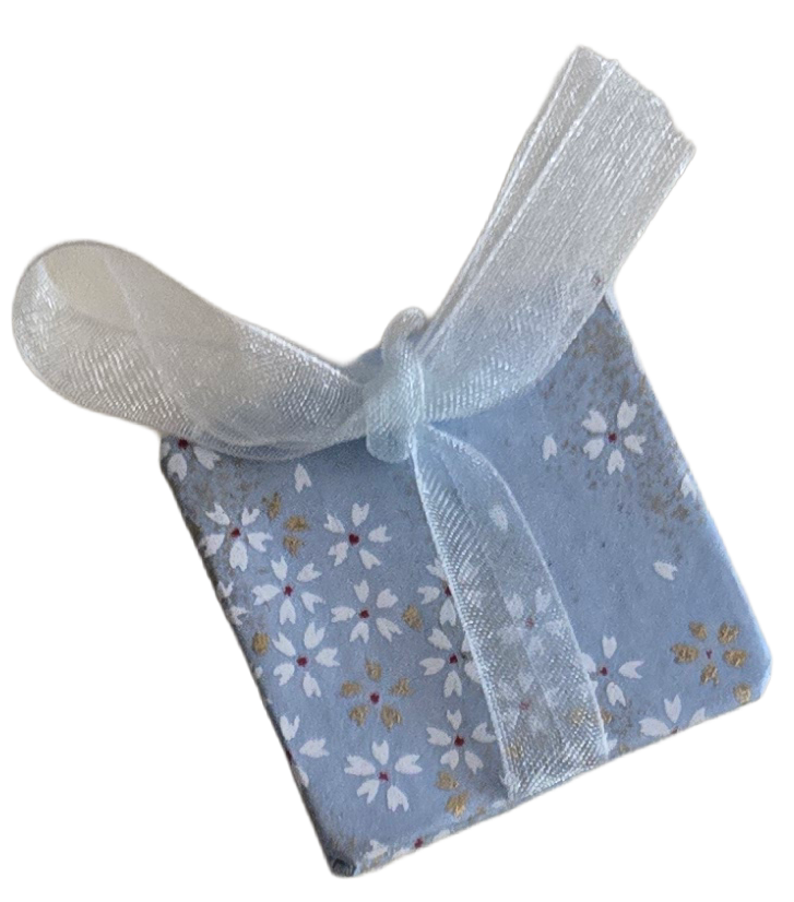 Small gift wrapped in floral paper with a white ribbon bow on top.