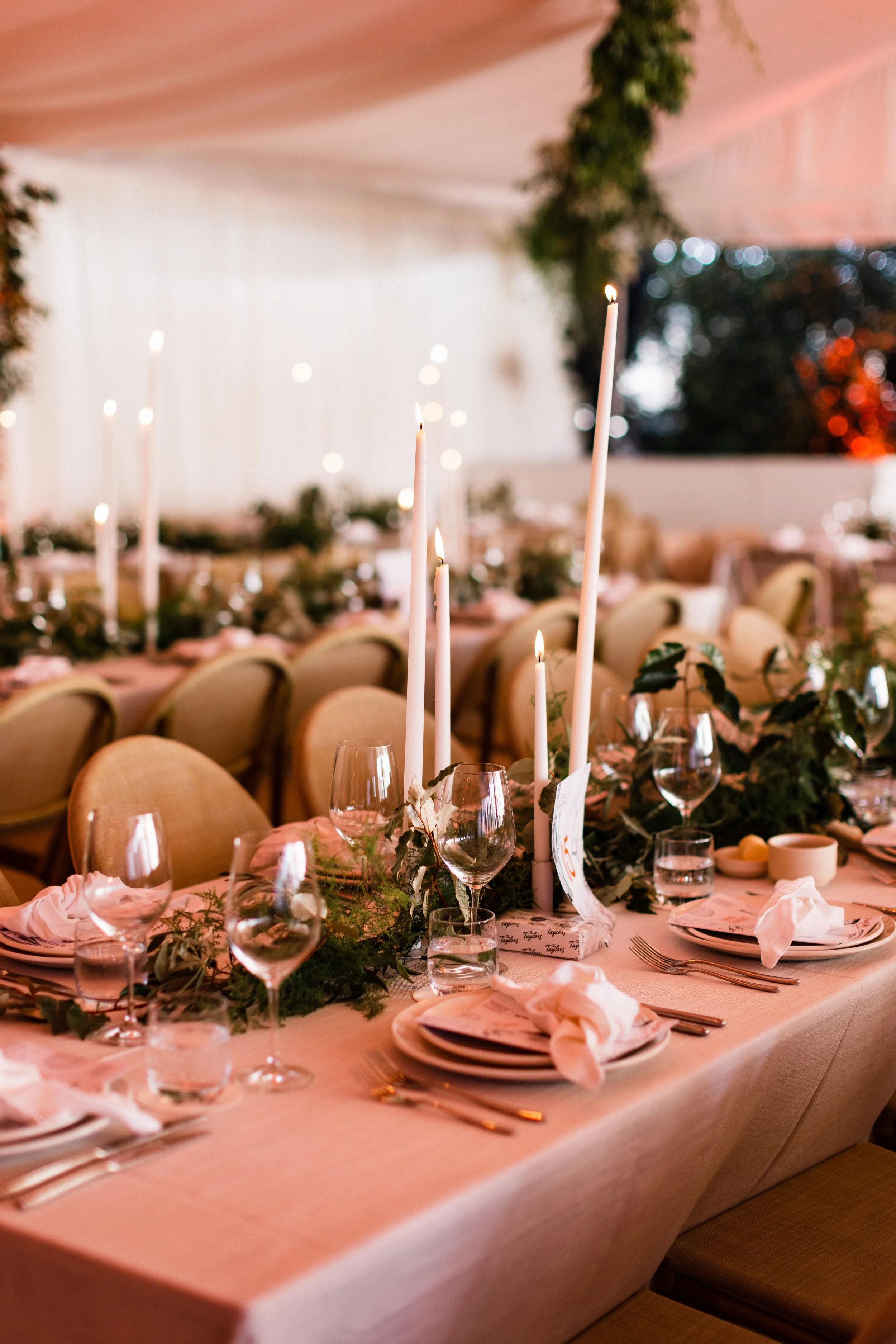 Long wedding table set with tall taper candles, a greenery runner and blush linen at a private Sorrento residence