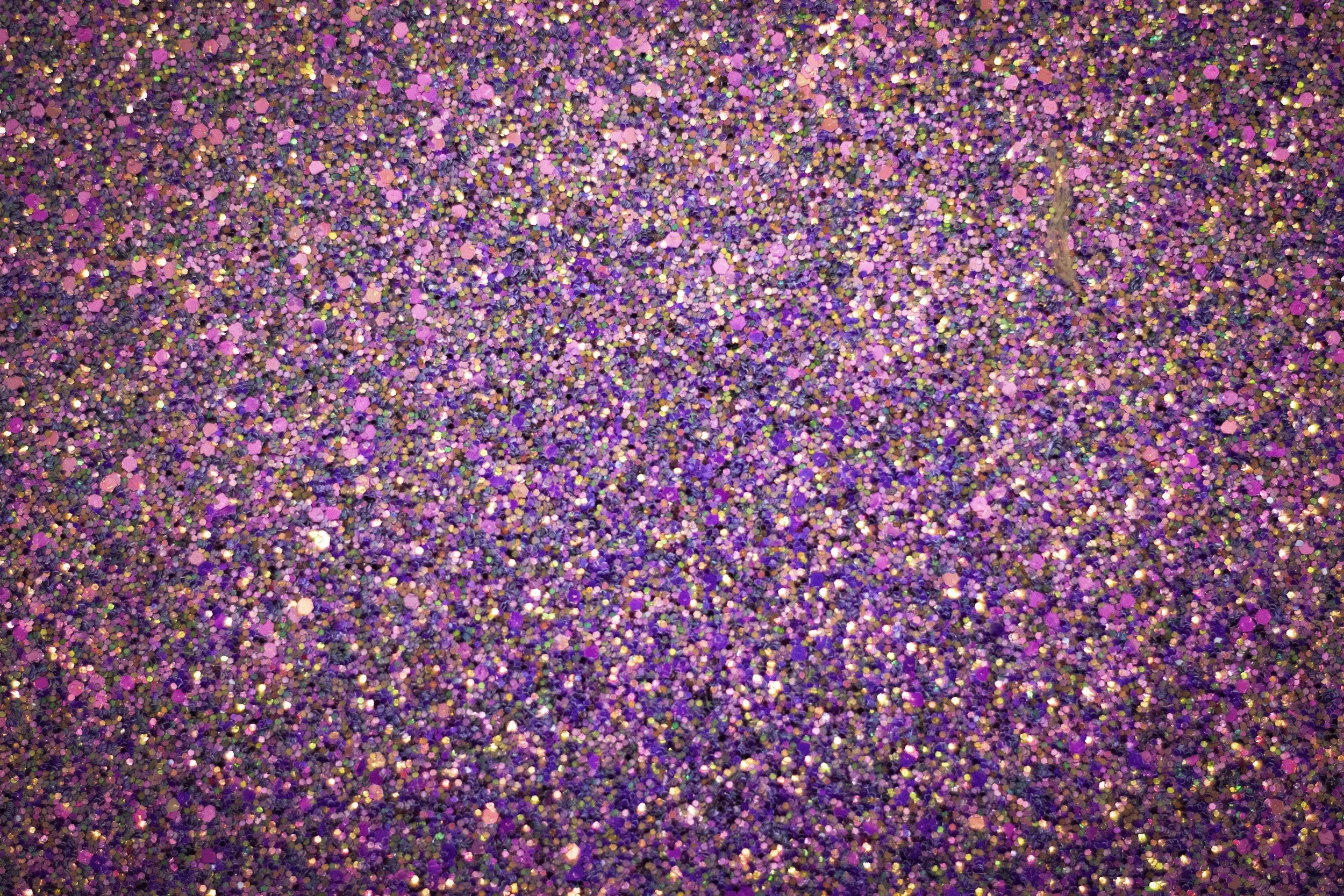 Close-up of multicolored glitter in pink, purple, and gold shades.