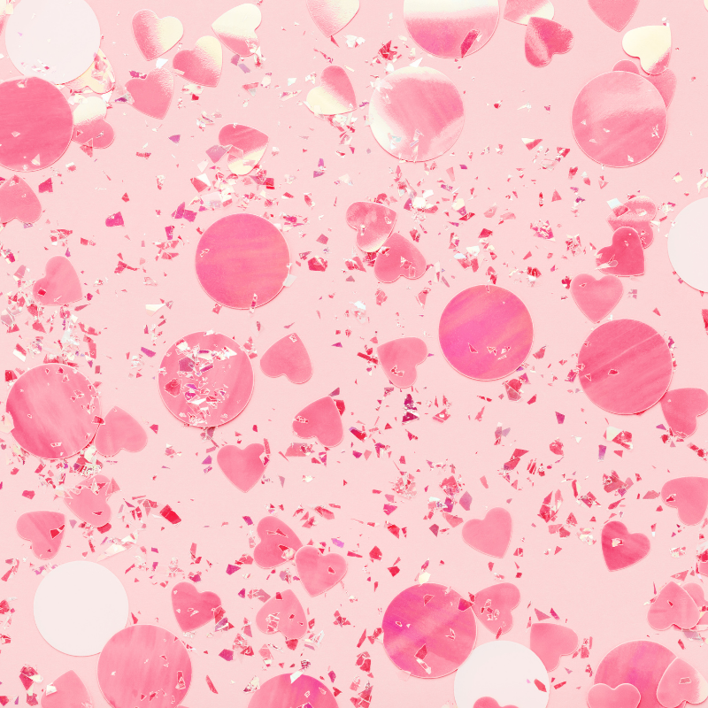 Pink background with scattered pink heart-shaped and circular confetti and glitter.