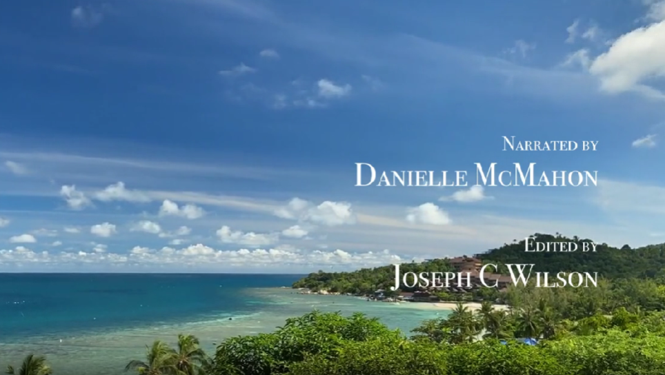 A scenic view of a coastline with a lush green landscape, blue ocean, and partly cloudy sky.