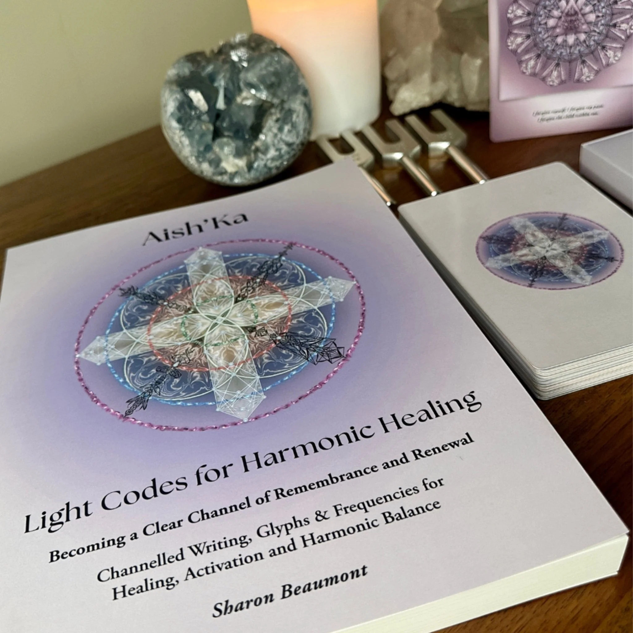 Aish'Ka's Codex by Sharon Beaumont alongside harmonic healing cards and ceremonial space, offering channeled writings, sacred glyphs and multidimensional frequency transmissions.