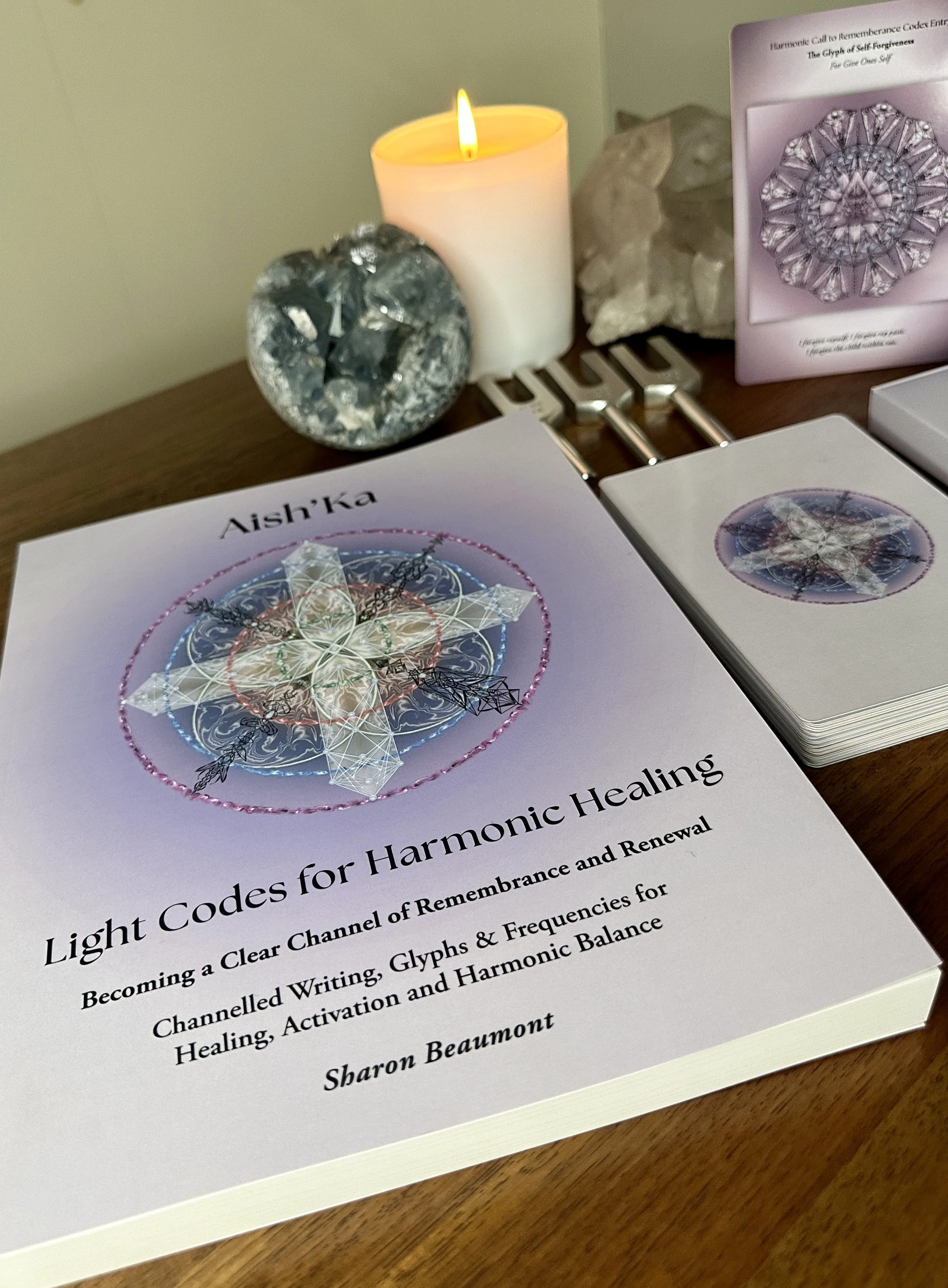 Aish'Ka's Codex by Sharon Beaumont alongside harmonic healing cards and ceremonial space, offering channeled writings, sacred glyphs and multidimensional frequency transmissions.