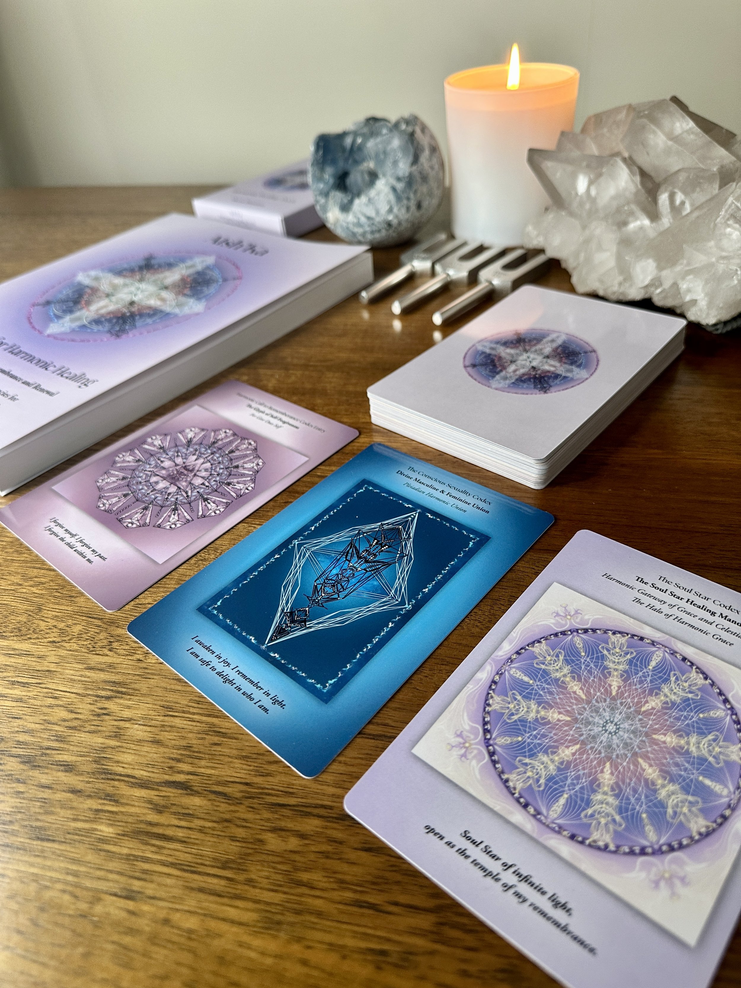 Aish'Ka Harmonic Healing Card Deck displayed with selected transmission cards, crystals, candle and tuning forks.