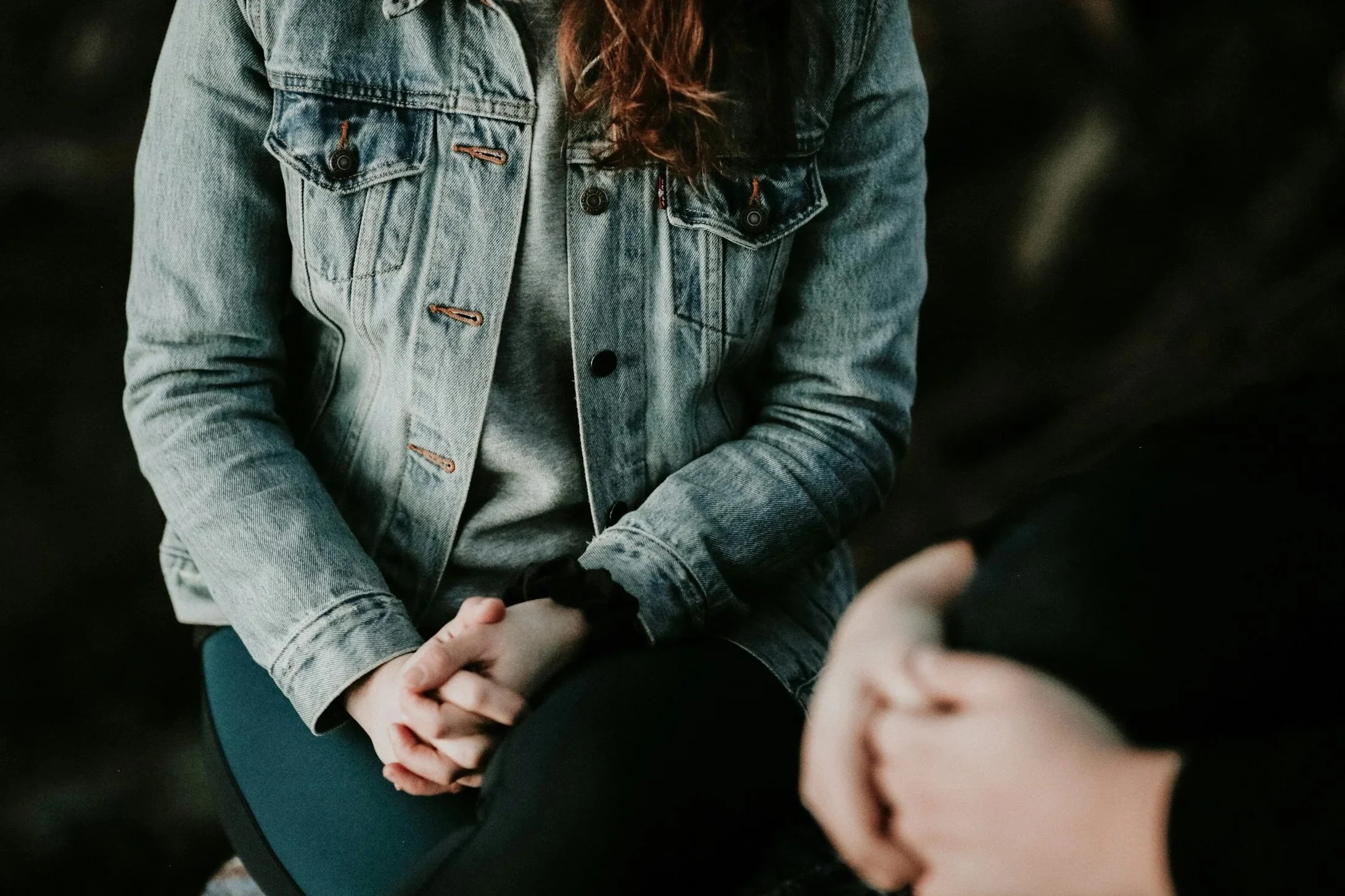 People holding hands, focusing on their intertwined fingers.