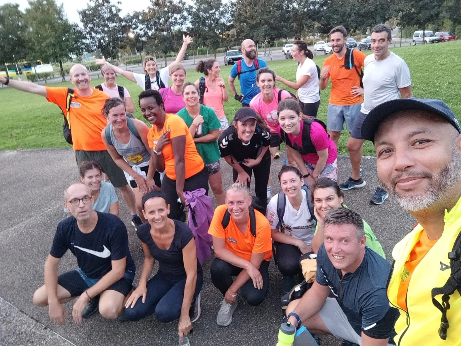 Groupe de coureurs ou randonneurs posant pour une photo de groupe en extérieur, certains souriants et décontractés.