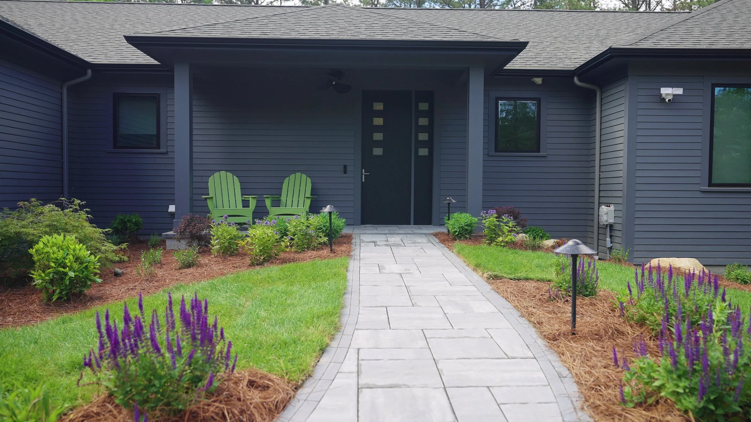 Paver walkway, landscape lighting, green grass, and plantings