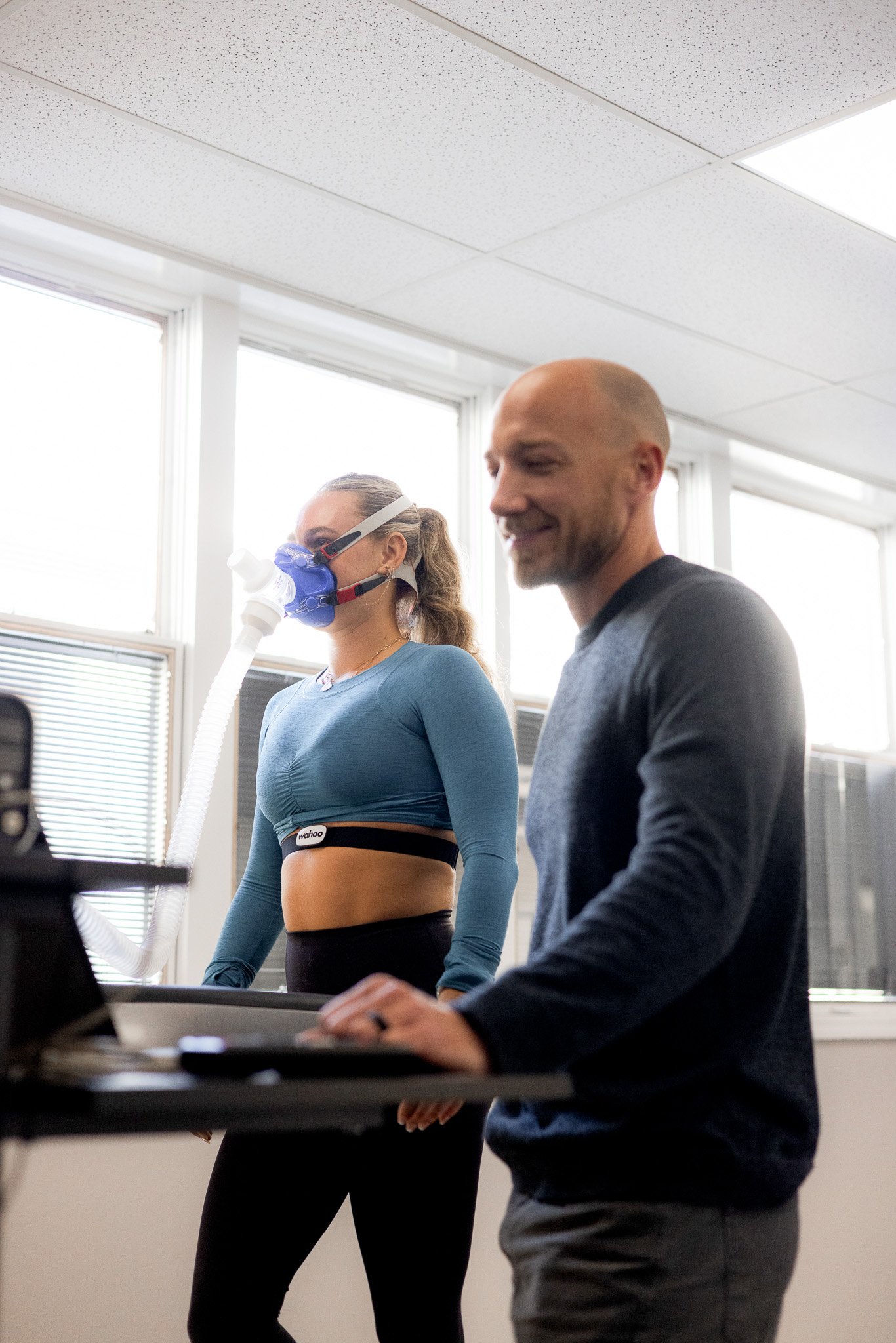 Bright office with patient and doctor interacting.  A CPET VO2 max test is being performed and interpreted.