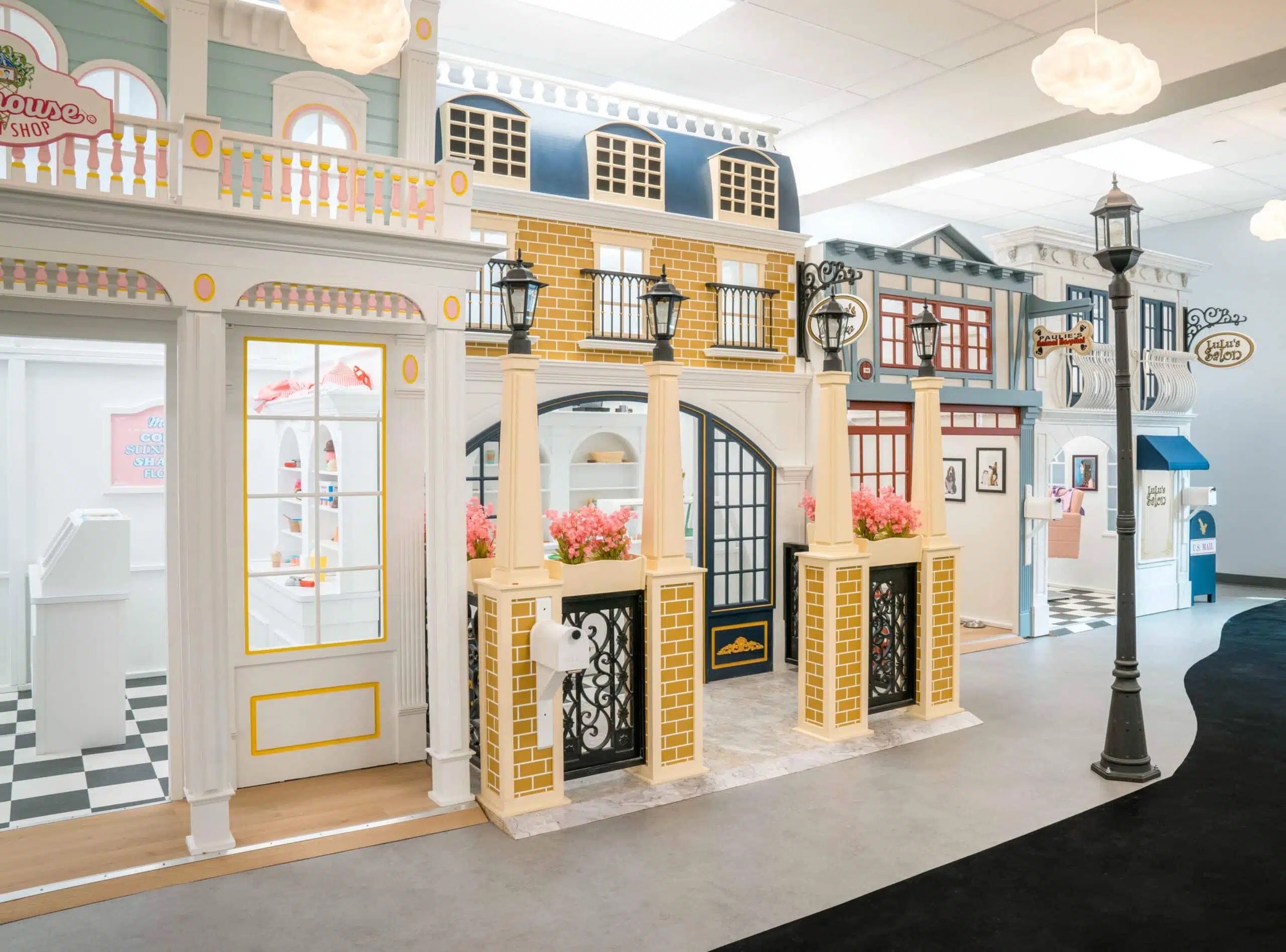 Indoor display of miniature buildings resembling a quaint town or neighborhood, with detailed facades, balconies, and decorative street lamps.