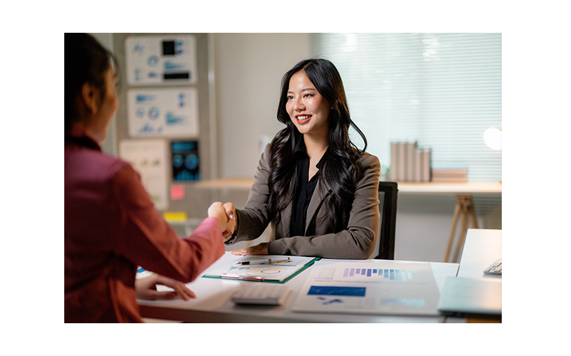 Female shaking hands at desk
