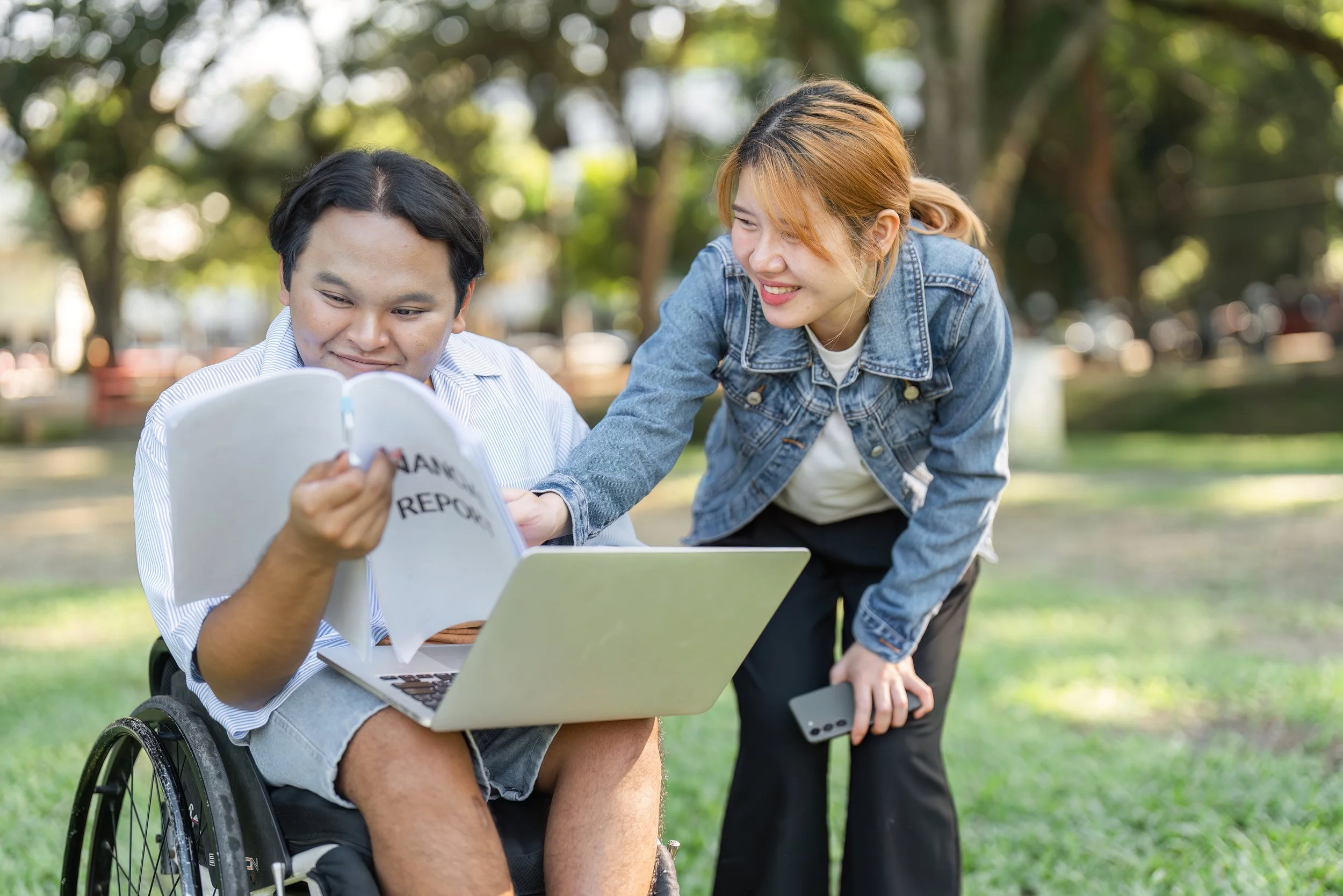 Young professional in wheelchair engaging with support worker