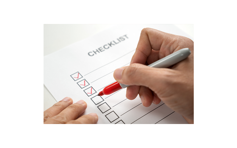 Hand with red marker marking a checklist box