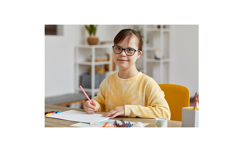 Female at home studying or drawing while looking at the camera