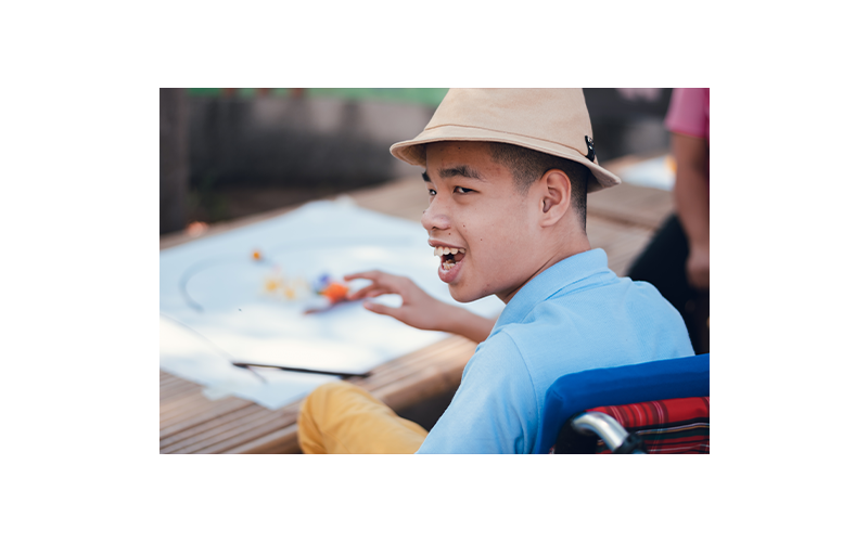 Young man participating in art activity, looking back towards camera
