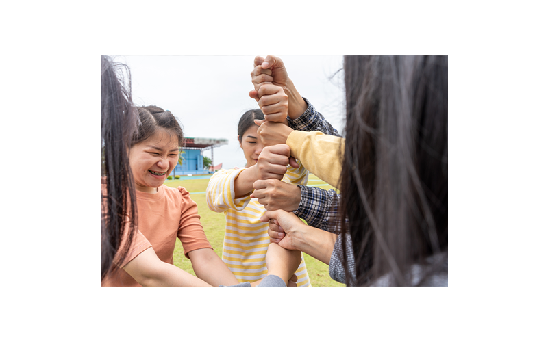Multiple people stacking hands to build connection