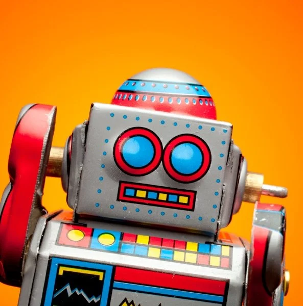 Tin toy robot on orange background