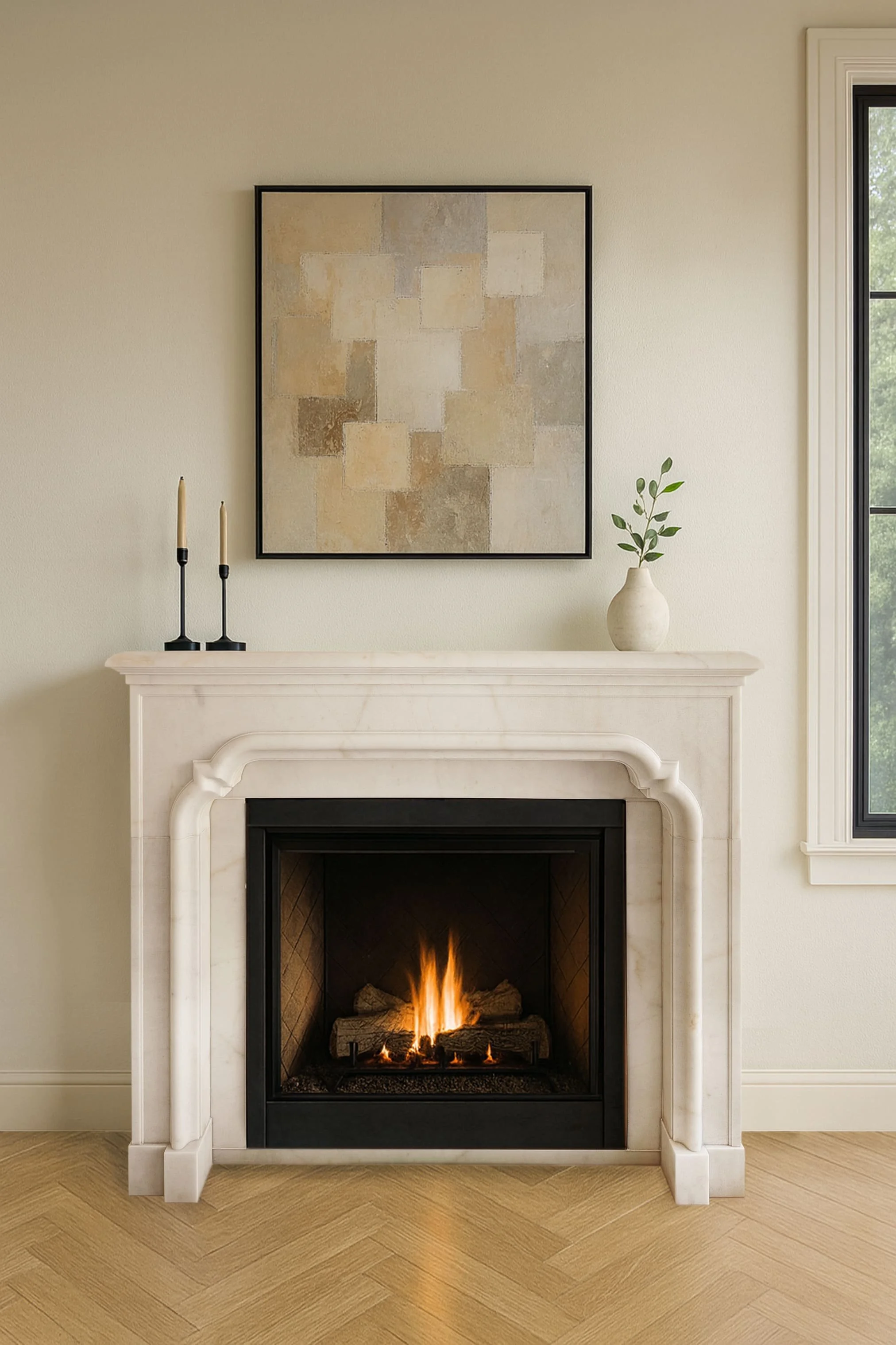 A cozy living room corner with a white fireplace with a small fire burning inside. On the mantel, there are two black candle holders with tall beige candles and a small white vase with green leaves. Above the mantel, a modern abstract painting hangs on the wall. To the right, a window shows a view of green trees outside.